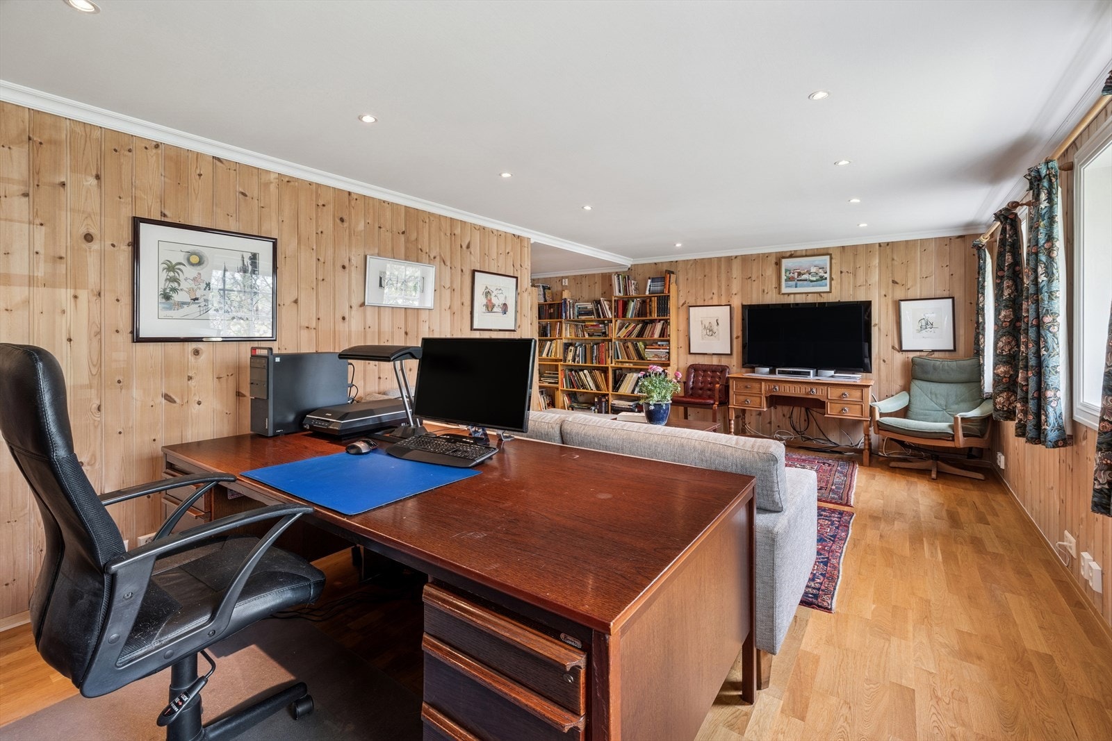 I boligens underetasje finner du kombinert stue og kontor. Galleribilde