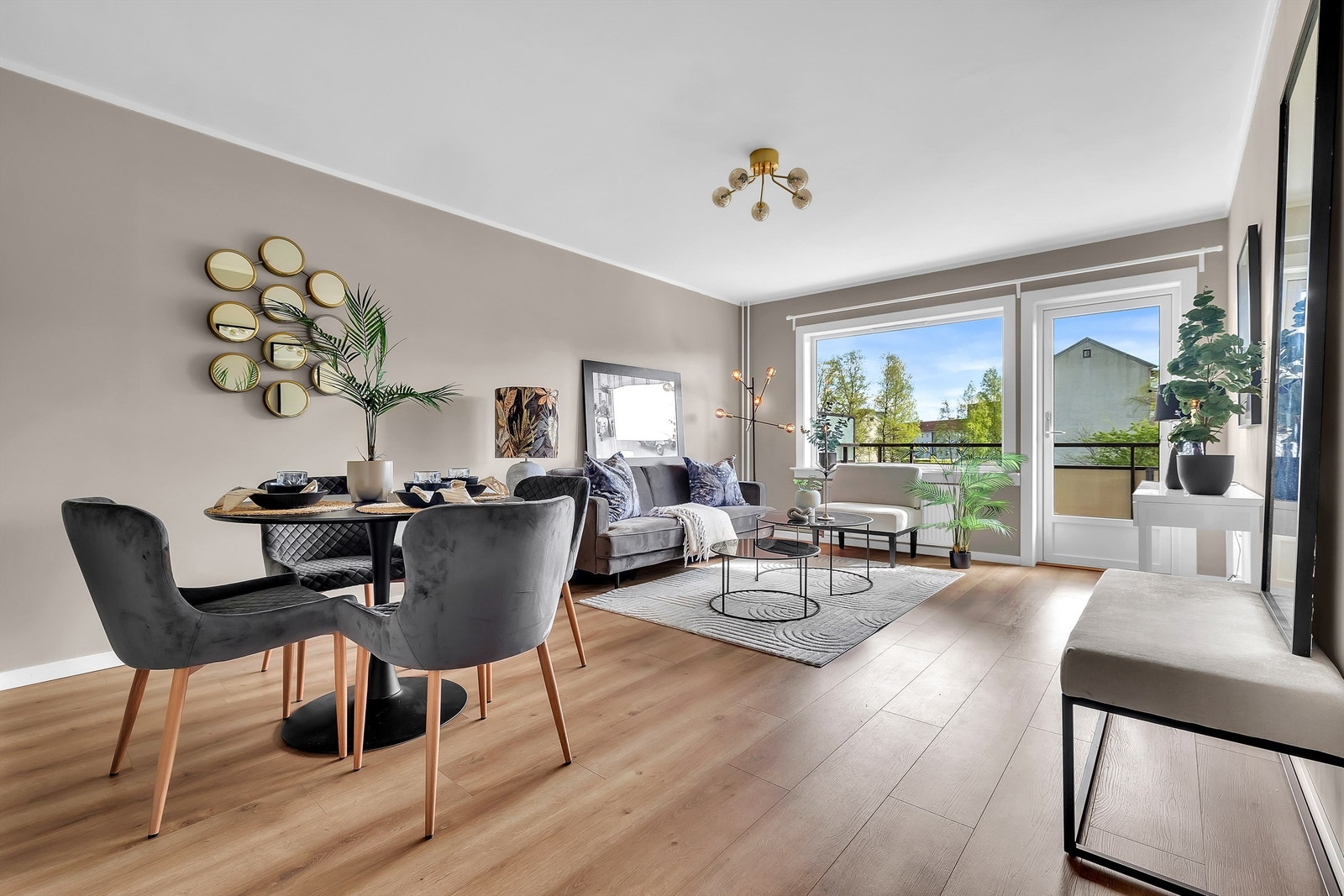 Lys og moderne stue med store vindusflater som gir rikelig med naturlig lys og utsikt mot grønne omgivelser. Galleribilde