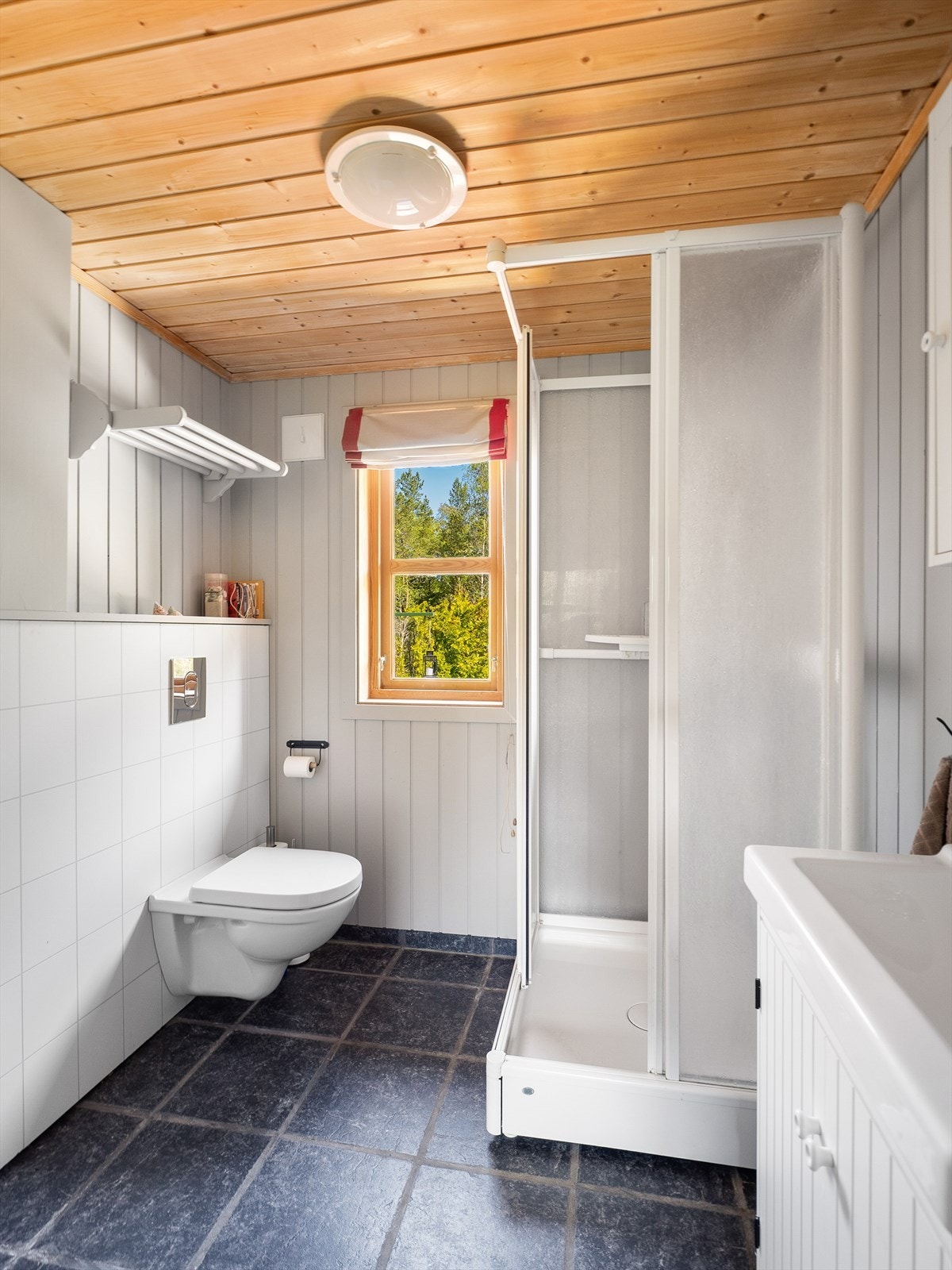 Badet har fliser og varmekabler i gulv, samt vegger med panel. Galleribilde