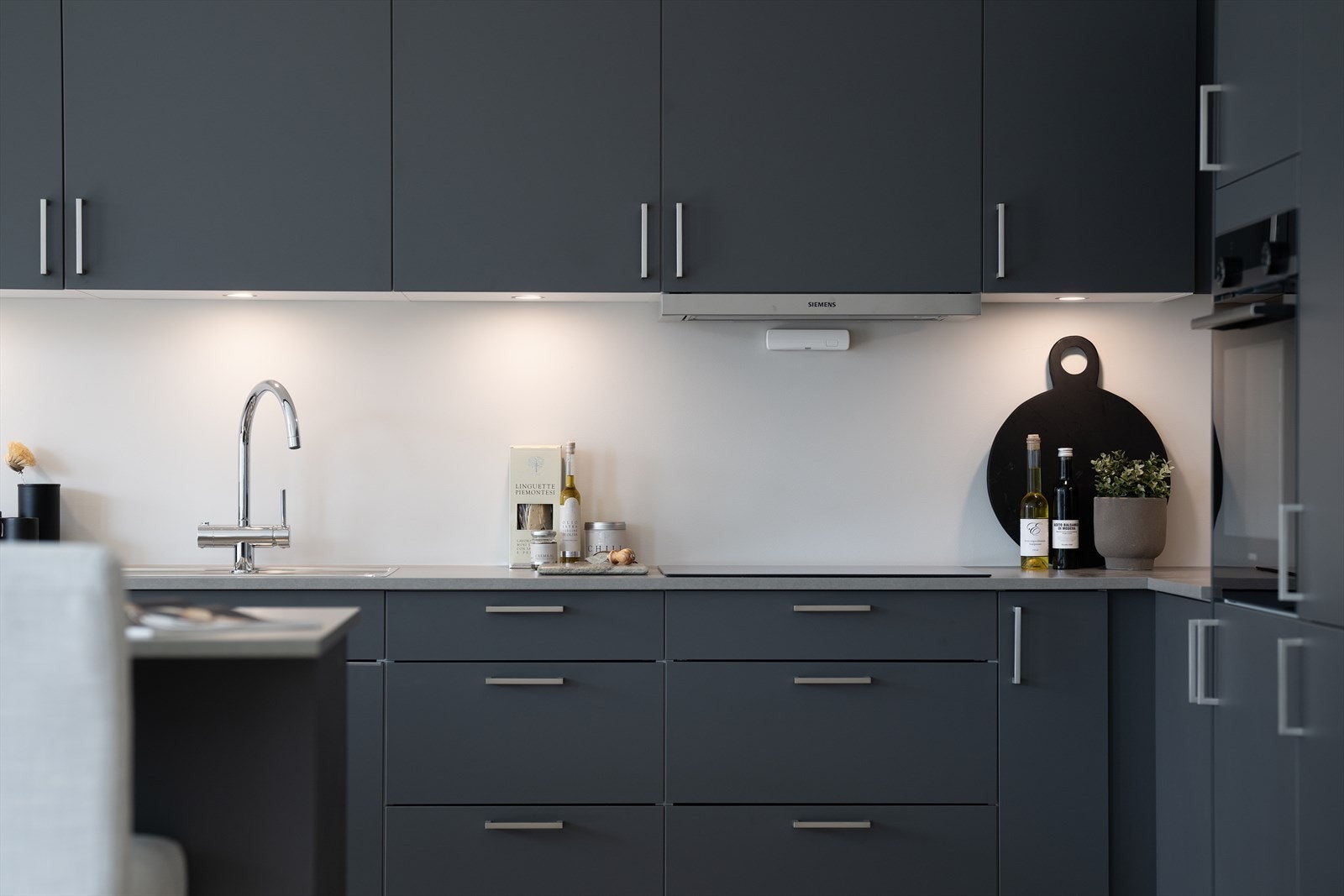 Kjøkkenet er utstyrt med integrerte hvitevarer som kjøl-/fryseskap, oppvaskmaskin, platetopp, stekeovn og komfyrvakt Galleribilde