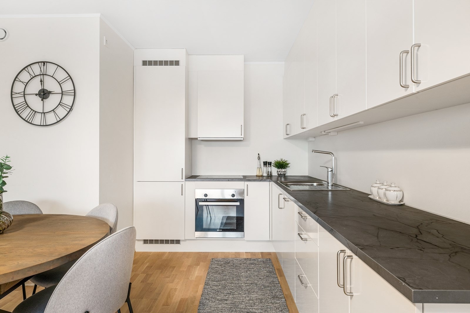 Kjøkkenet har innredning med glatte fronter. Benkeplaten er av laminat med nedfelt oppvaskkum. Integrert steketopp, komfyr, kjøl/fryseskap og oppvaskmaskin. Galleribilde