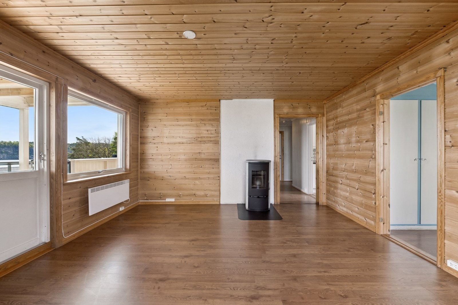Stue med laminatgulv og furupanel Galleribilde