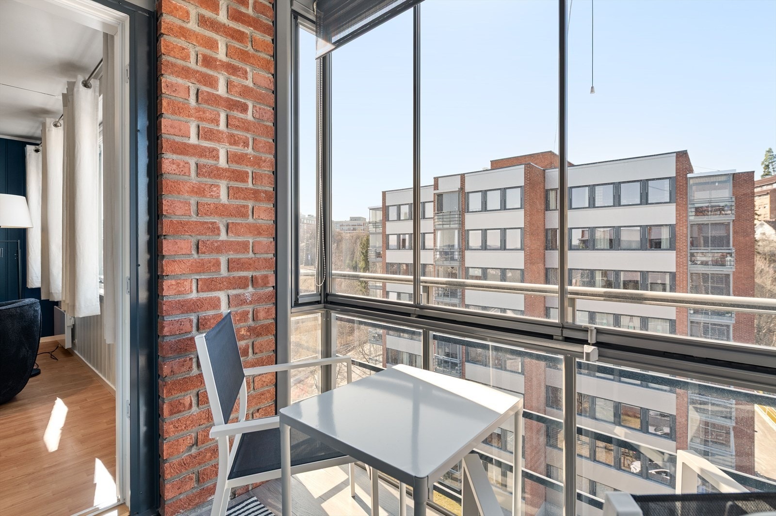 Solrik innglasset balkong med ettermiddagssol. Galleribilde