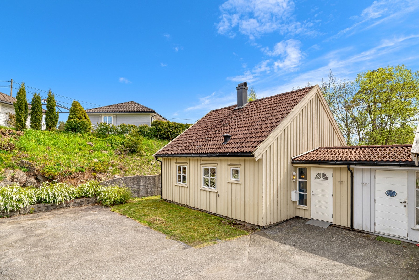 Boligen ligger i et lite tun med tre andre, det er plass til én bil på felles oppstillingsplass, samt plass til en bil ved siden av huset Galleribilde