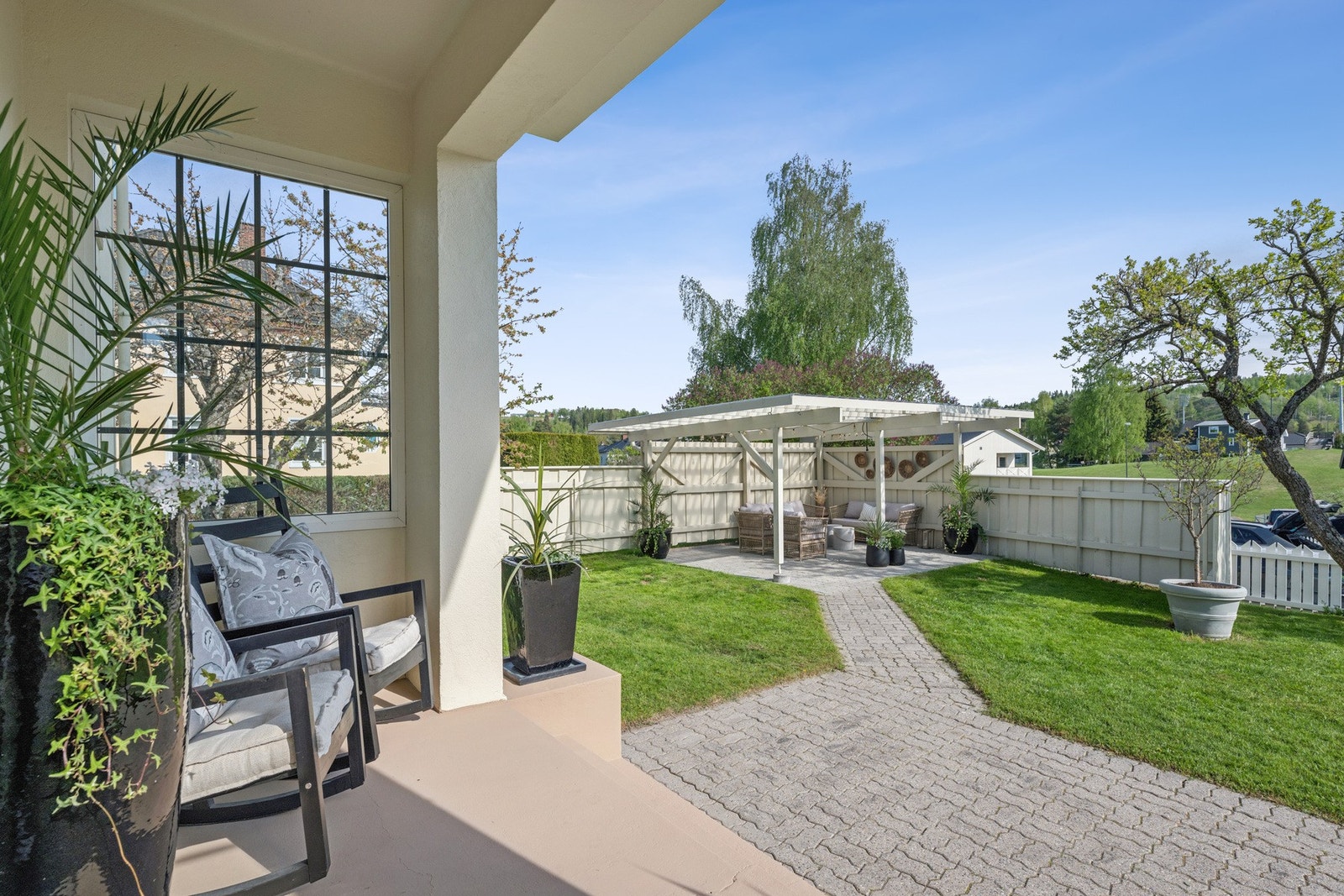 Hage med hellelagt sti og en pergola som gir rom for både sol og skygge. God atmosfære og fine soner for uteliv. Galleribilde