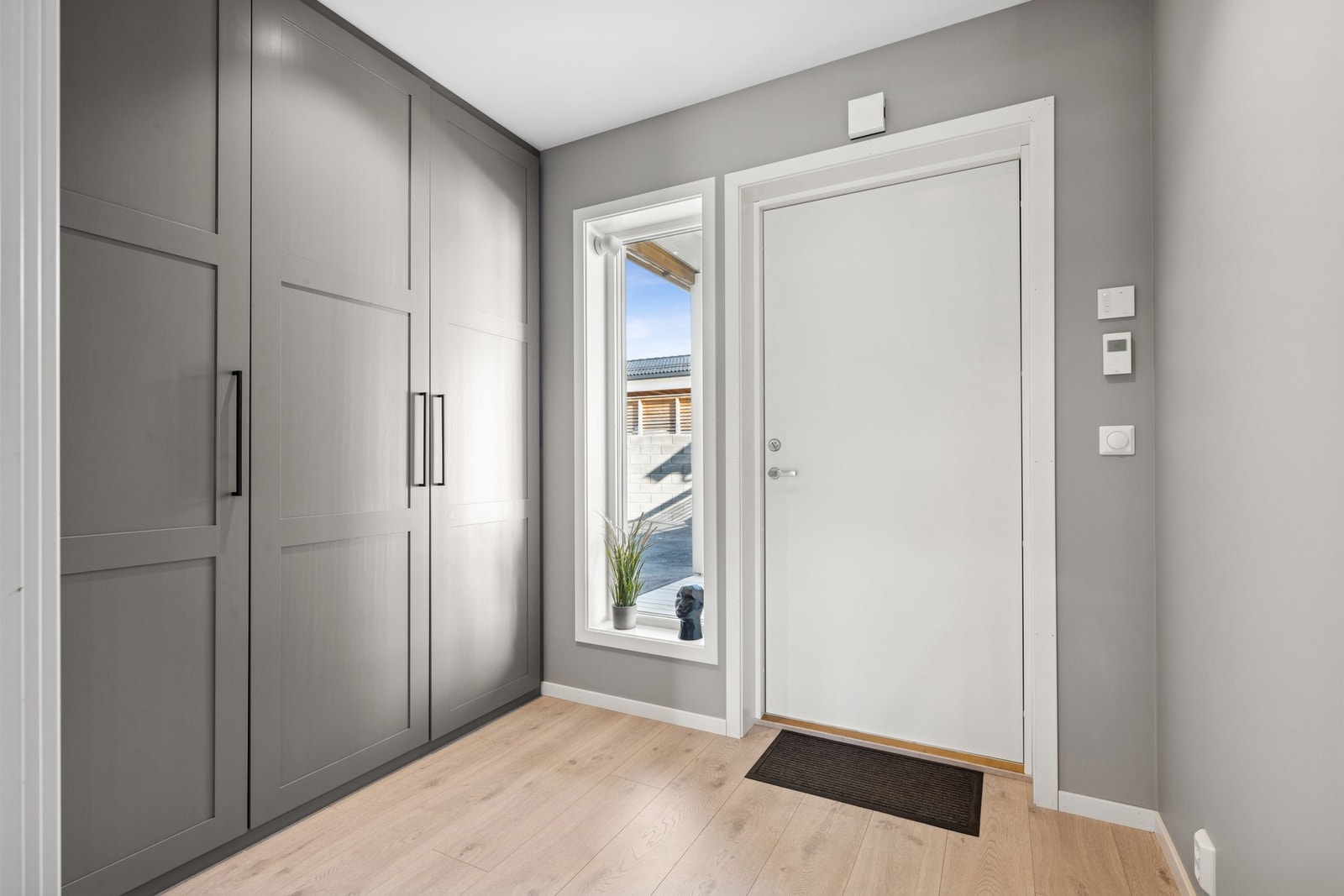 Her kommer du inn i en luftig entré med spesialbestilt garderobe som passer perfekt inn i rommet. Galleribilde