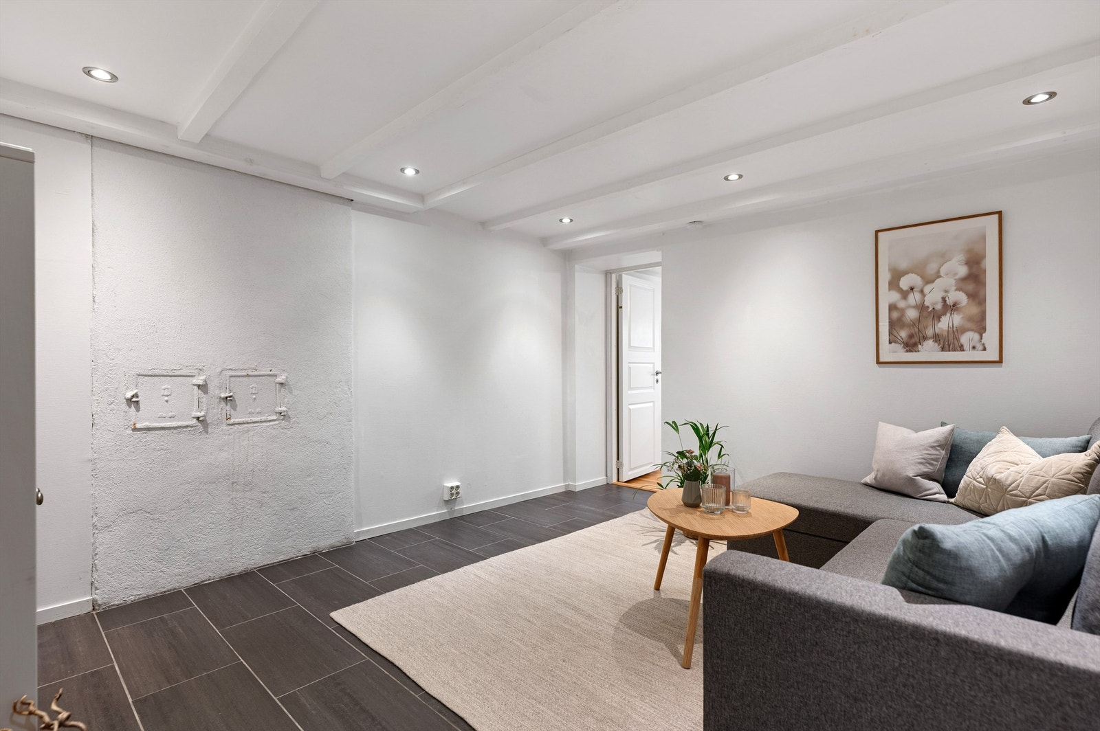 Kjeller stue med fliser på gulv og spotter i tak. Galleribilde