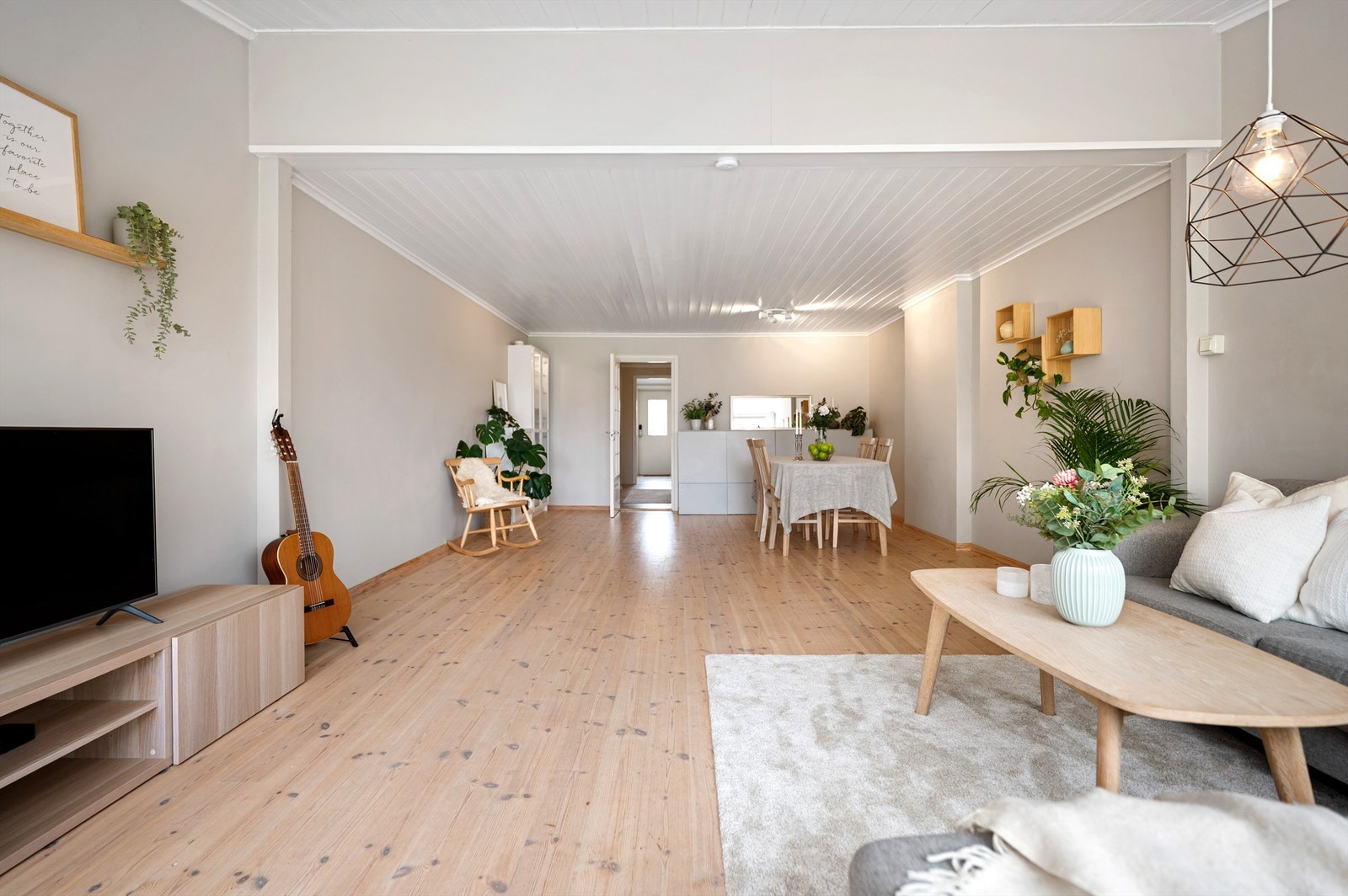 Åpen og lys stue med furugulv og lysmalte vegger. Galleribilde