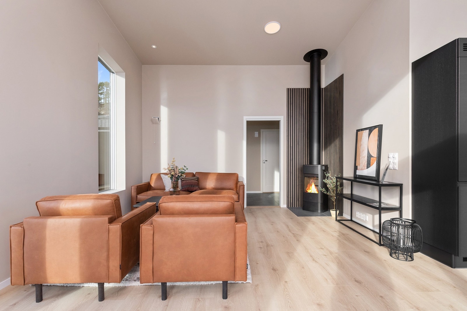 Stua er malt i delikate farger og har en flott peisovn. Galleribilde