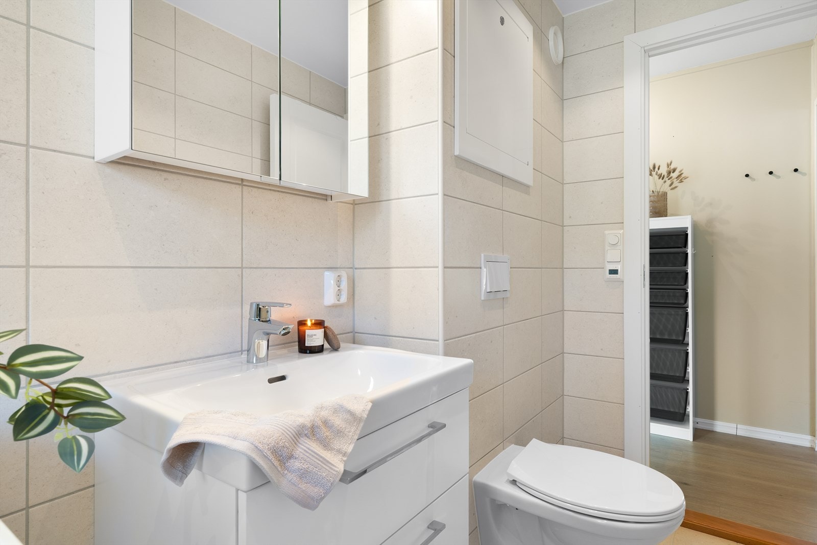 - Badet er innredet med vegghengt toalett, benkeskap med servant, speilskap, dusjhjørne med glassdør og opplegg for vaskemaskin - Galleribilde