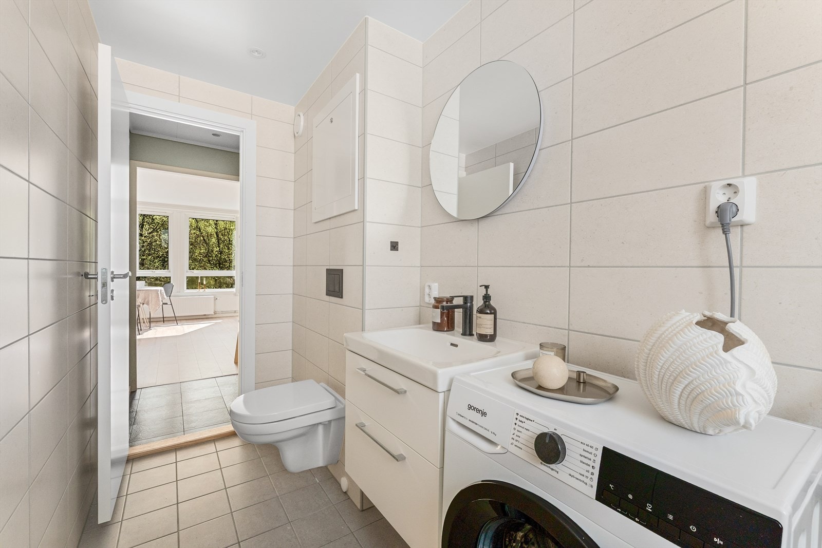 - Badet inneholder vegghengt toalett, benkeskap med servant, dusjvegg, fordeler skap til "rør i rør" og opplegg for vaskemaskin - Galleribilde