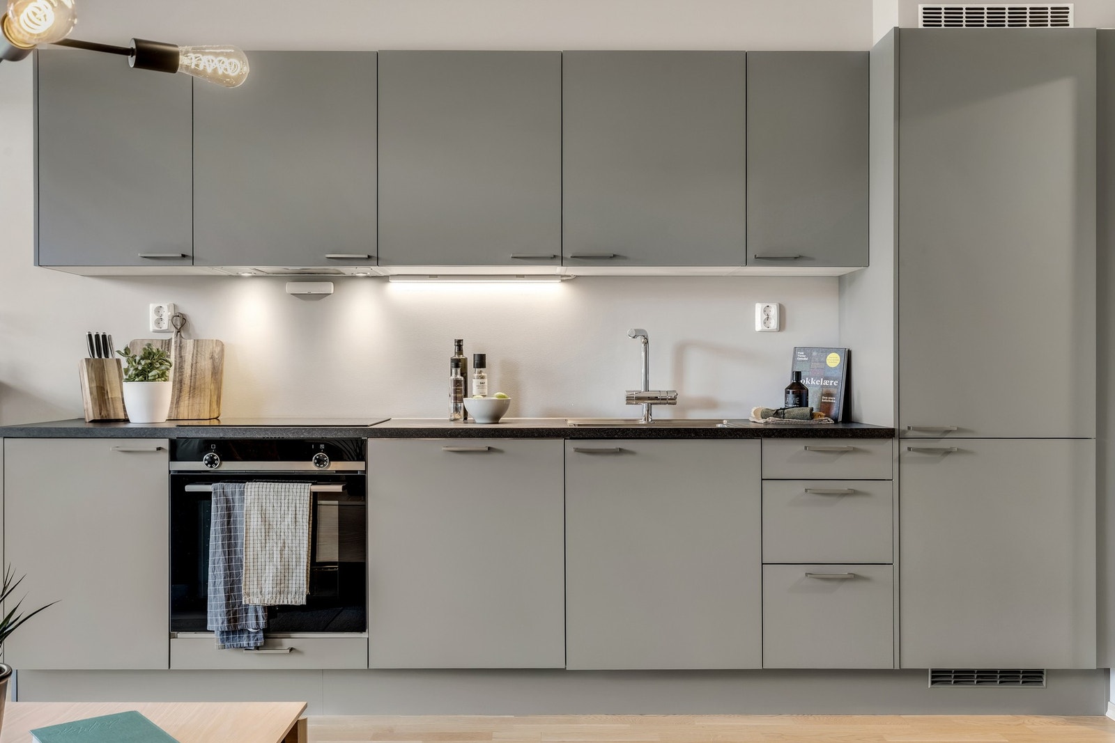 Moderne og innbydende kjøkken som innehar alt av nødvendige hvitevarer, blant annet integrert platetopp, stekeovn, oppvaskmaskin og kjøl/fryseskap. Galleribilde