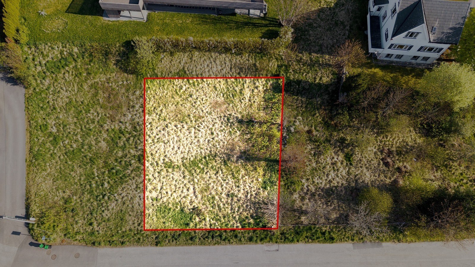 Dronebilde av tomten sett fra fugleperspektiv med ca. tomtegrenser markert Galleribilde