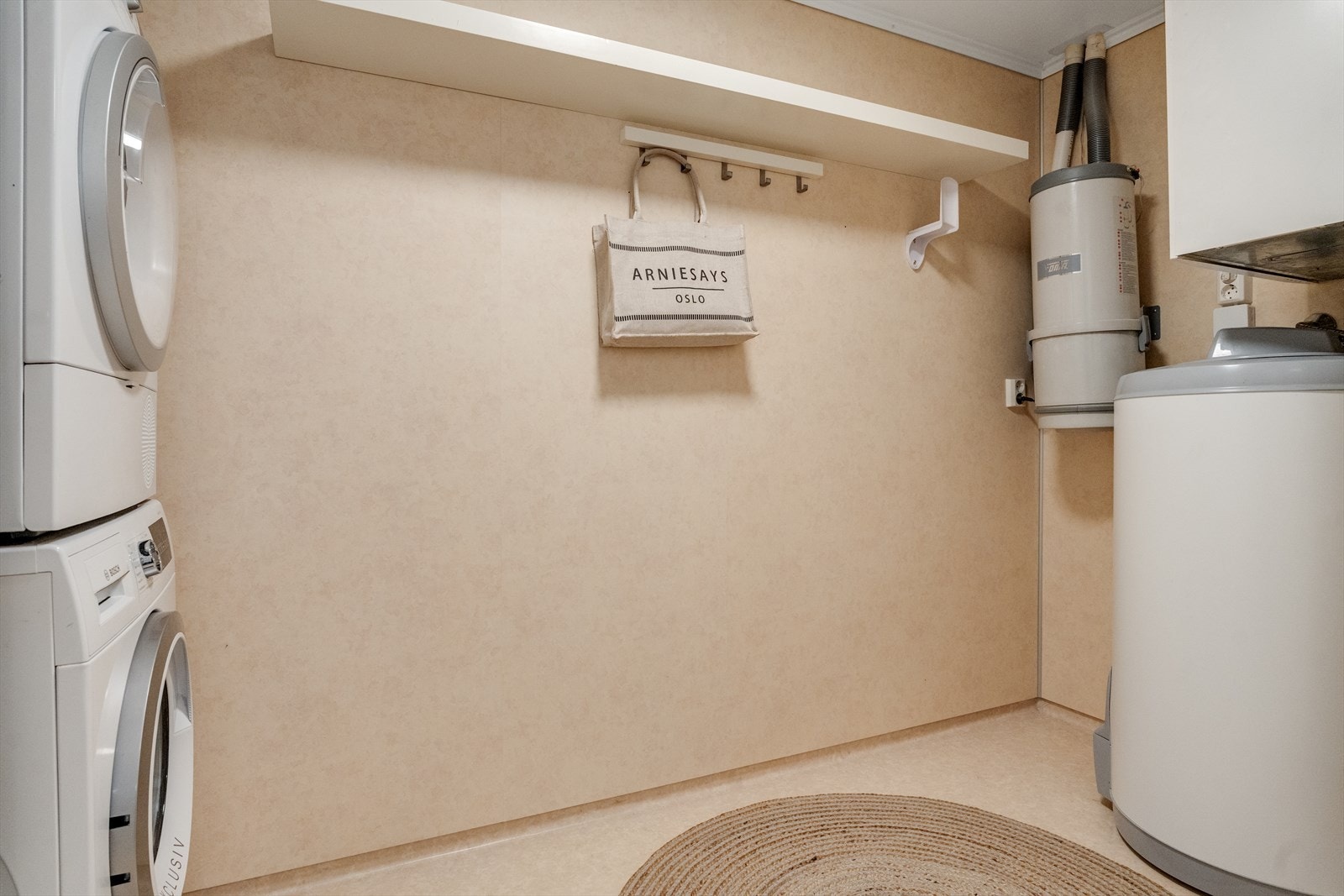 Praktisk vaskerom med opplegg for vaskemaskin og plass til oppbevaring. Galleribilde
