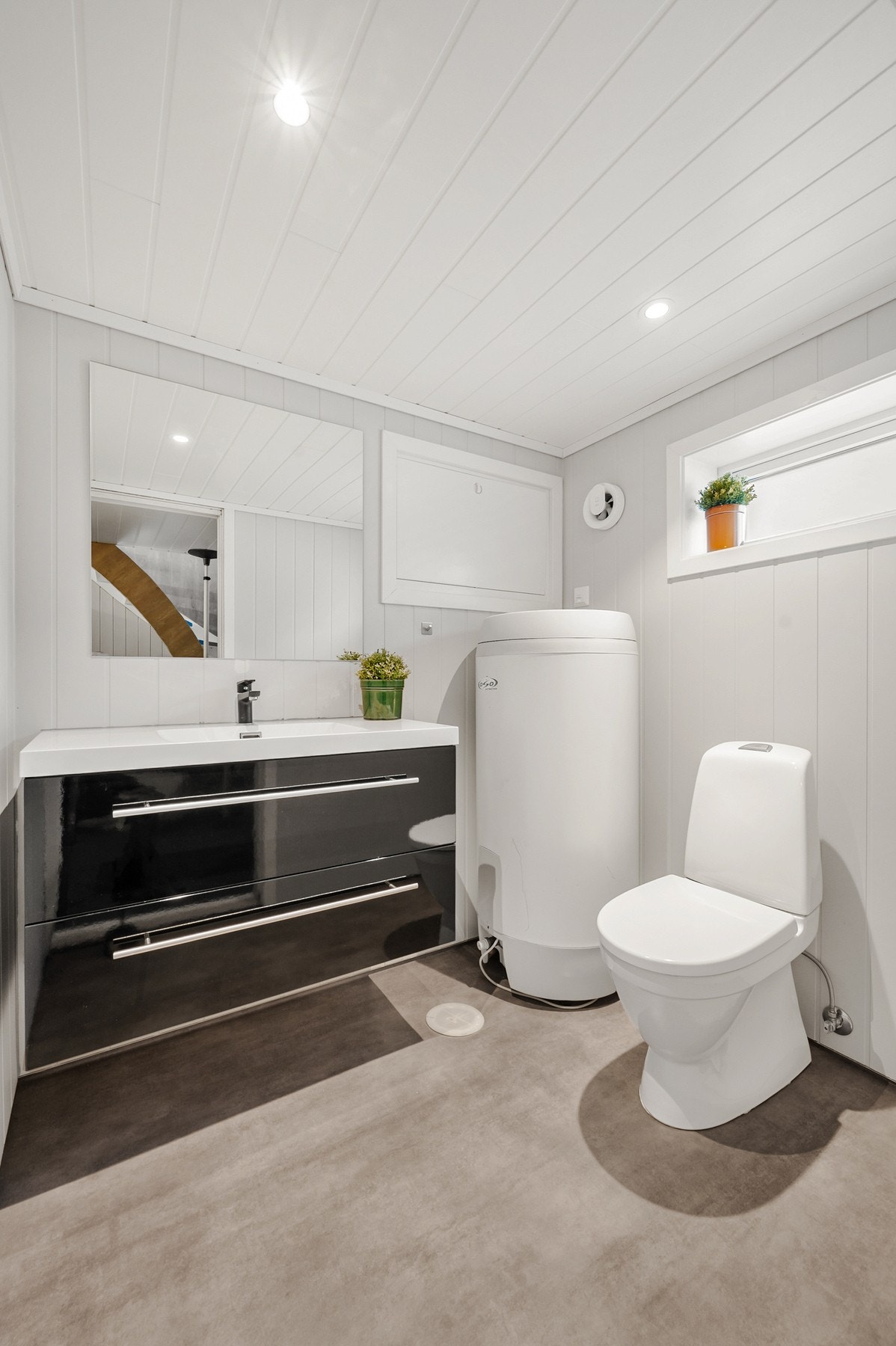 Toalettrom med bred servant og gulvstående toalett. Det er varmekabler i gulvet for ekstra komfort. Varmtvannstanken er fra 2011 og er på 200 liter. Galleribilde