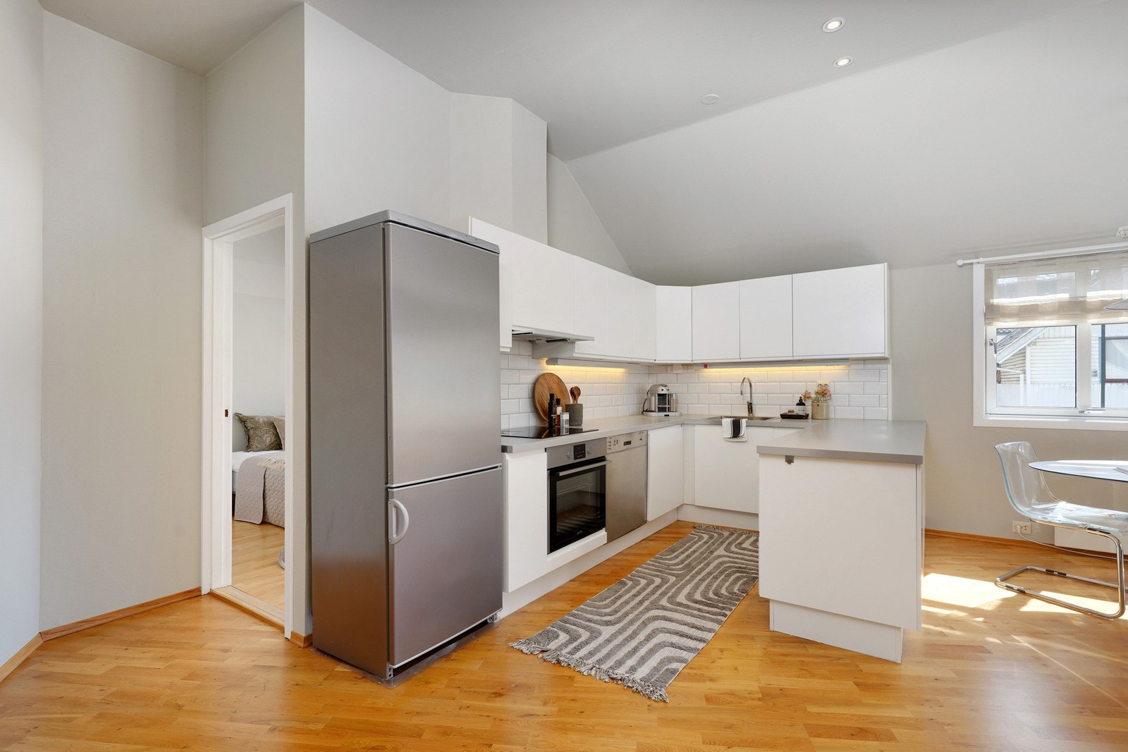 Lyst lekkert kjøkken byr på rikelig med skap- og benkeplass Galleribilde