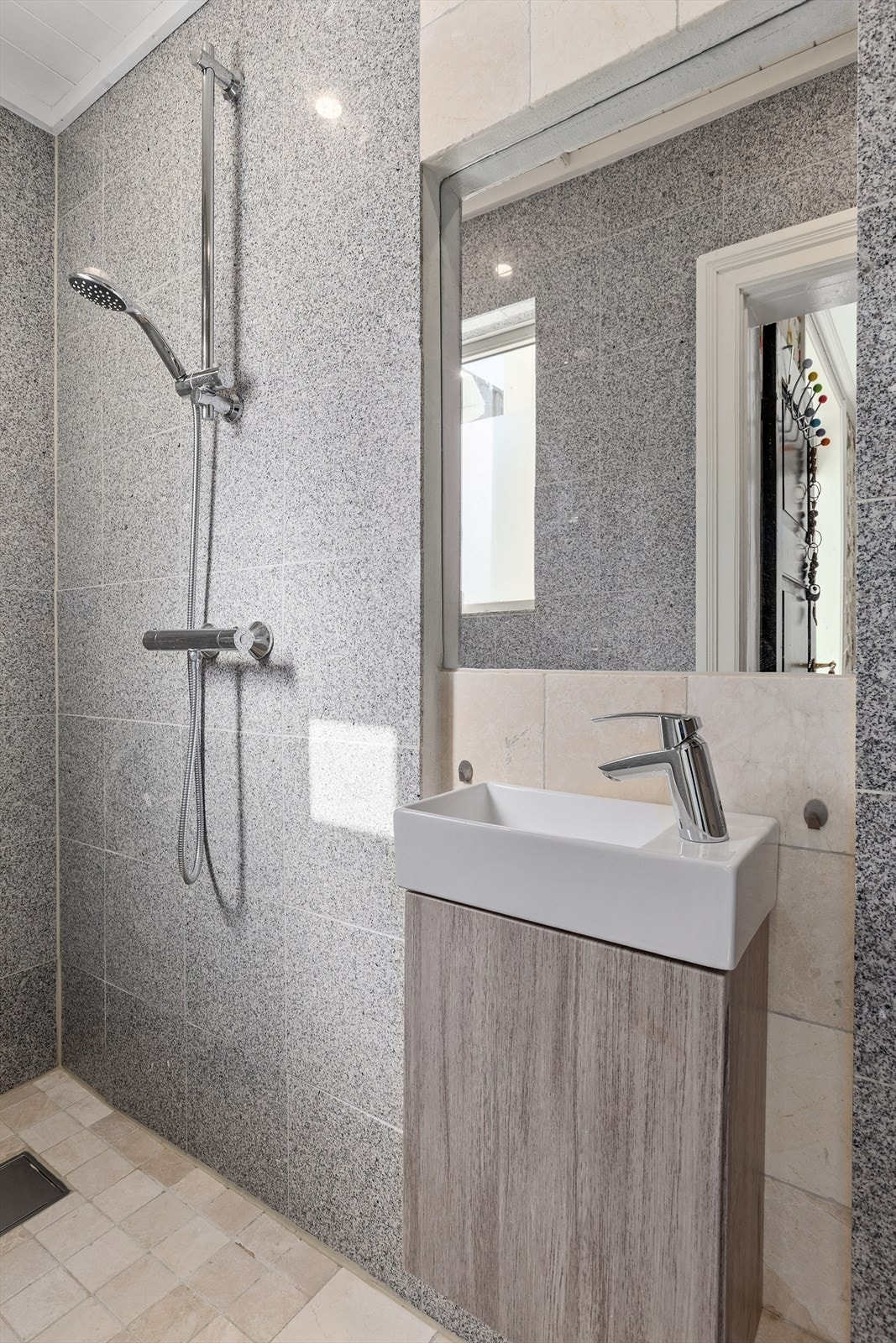 Det andre badet er også pent flislagt med dusjhjørne og vegghengt skap med ovenpåliggende servant. Galleribilde