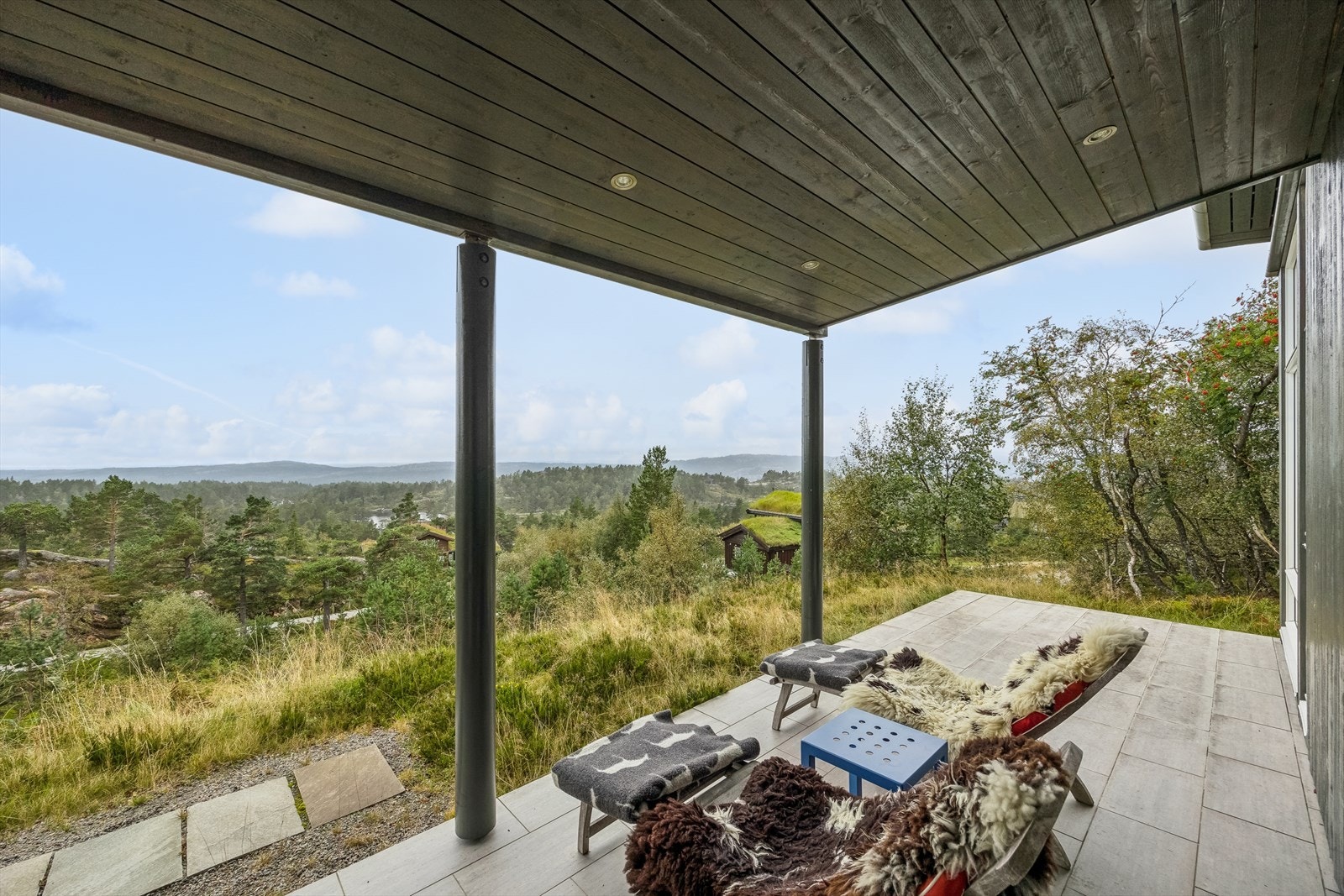 Ved inngangspartiet er det en flislagt platting, hvor deler av denne er takoverbygget. Galleribilde