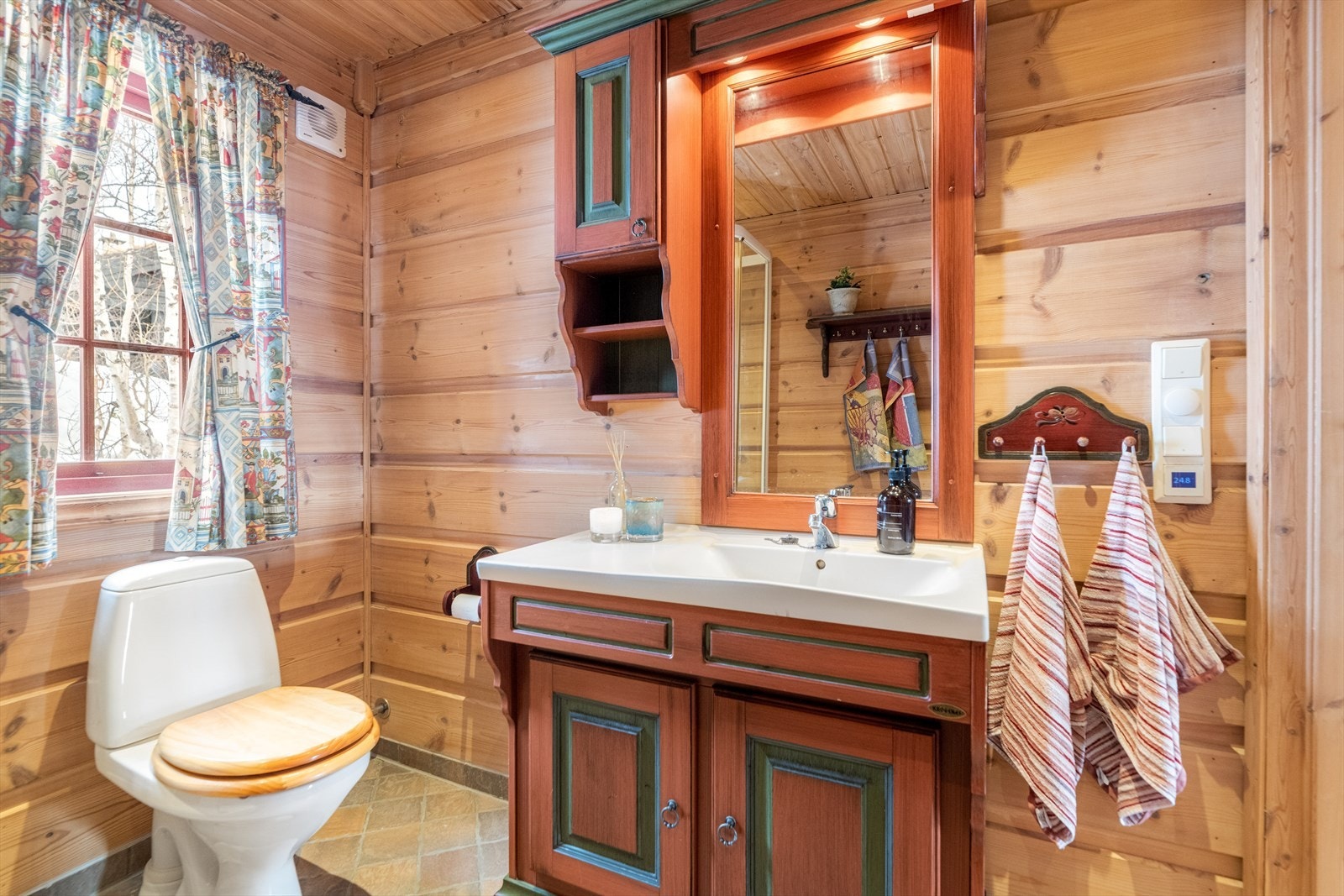 Pent baderom plassert mellom de to soverommene i hovedetasjen. Her er det flislagt gulv med varmekabler, panel på vegger og i himling. Galleribilde