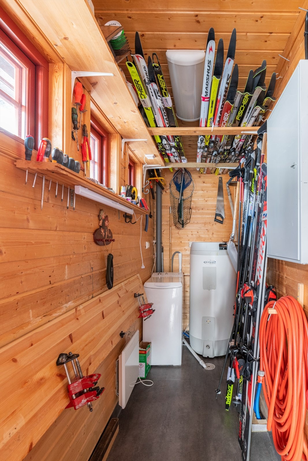 Tilliggende hovedinngangen er det en svært praktisk utvendig bod med belegg på gulv og panel på vegger og i himling. Her er hyttas varmtvannsbereder på ca. 200 liter plassert og boligens sikringsskap med automatsikringer. I tillegg fin lagringsplass. Galleribilde