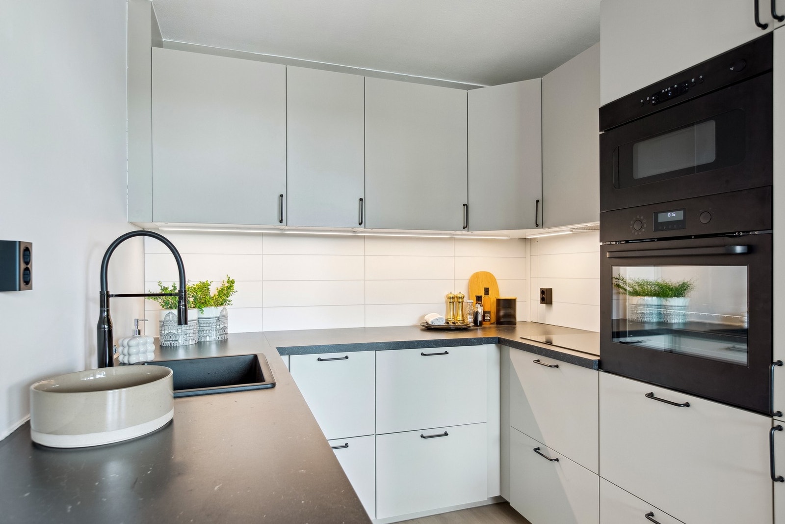 Kjøkkenet har en moderne og stilren utforming med praktiske skuffer og skap. Galleribilde