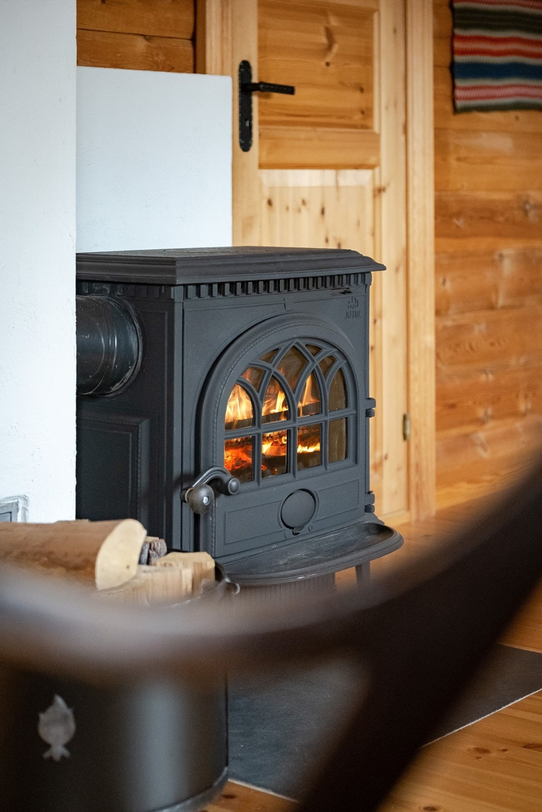 Stuen i tilbygget del har en koselig peisovn som gir god varme på kaldere høst- og vinterdager. Galleribilde