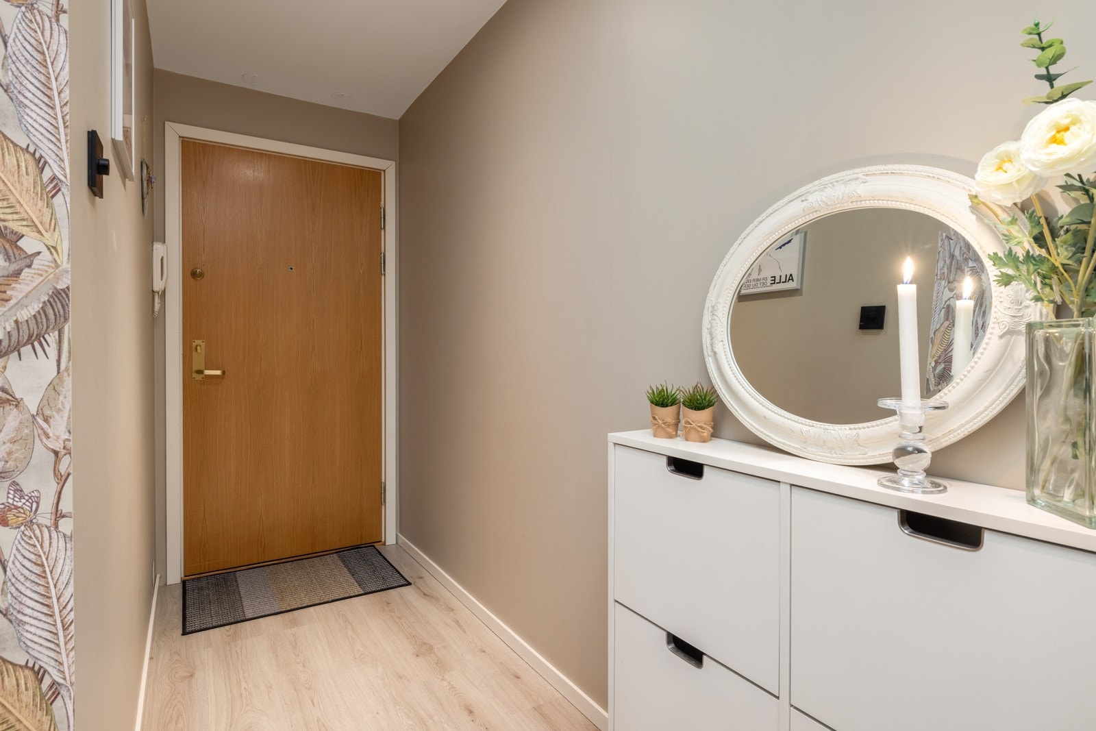 En lys og innbydende entré som gir et godt førsteinntrykk av boligen. Galleribilde