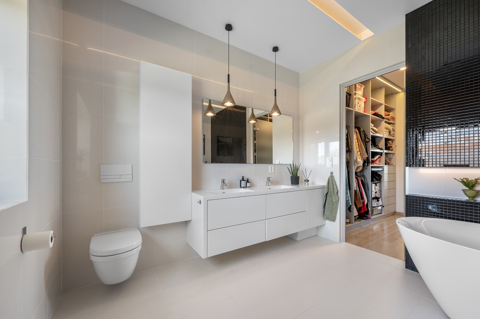 Den moderne baderomsinnredningen gir god plass til oppbevaring av håndklær og hygieneartikler. Galleribilde