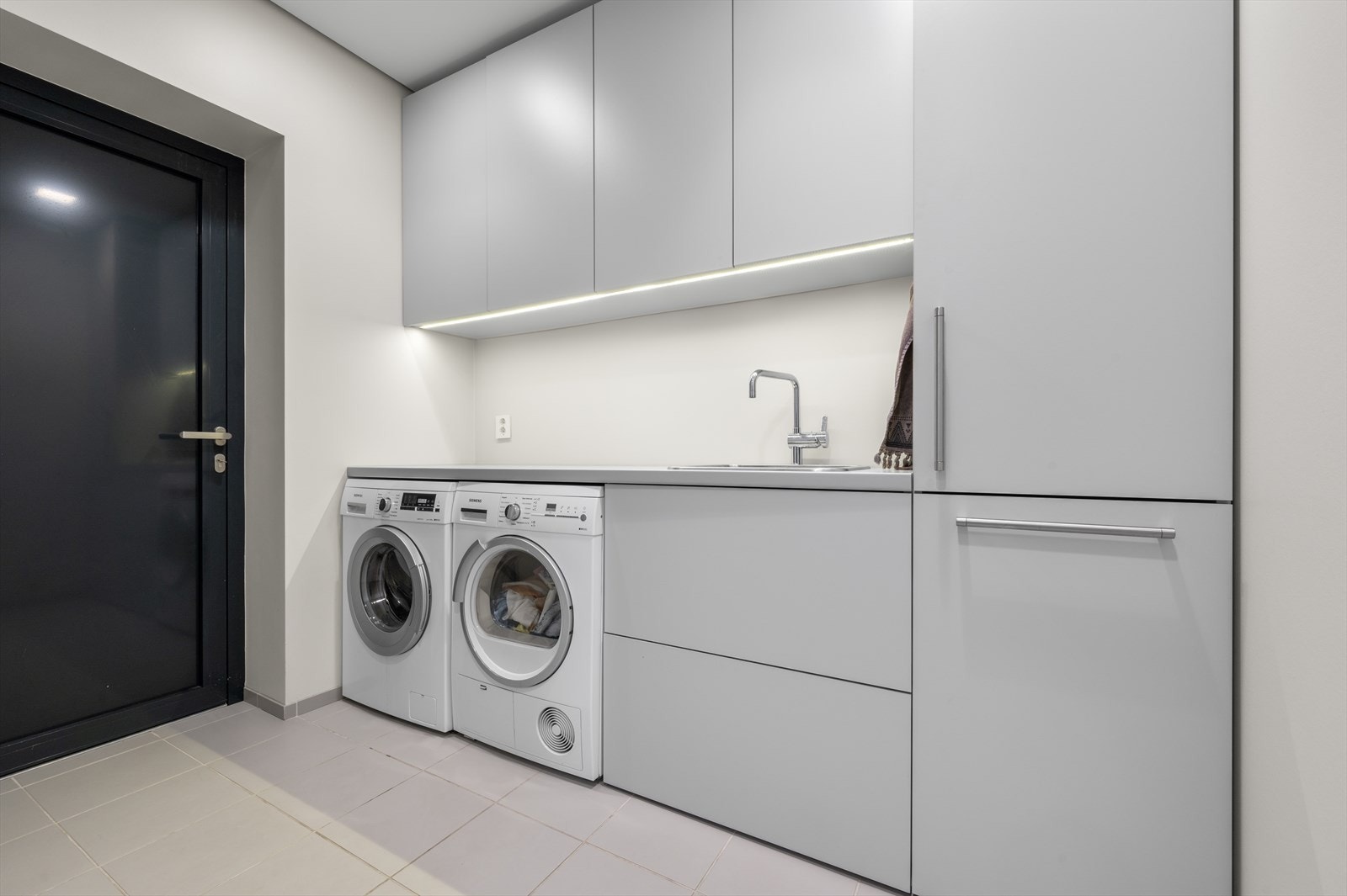 Et vaskerom i underetasjen forenkler hverdagen, og rommet har egen praktisk utgang til inngangssiden av huset. Galleribilde