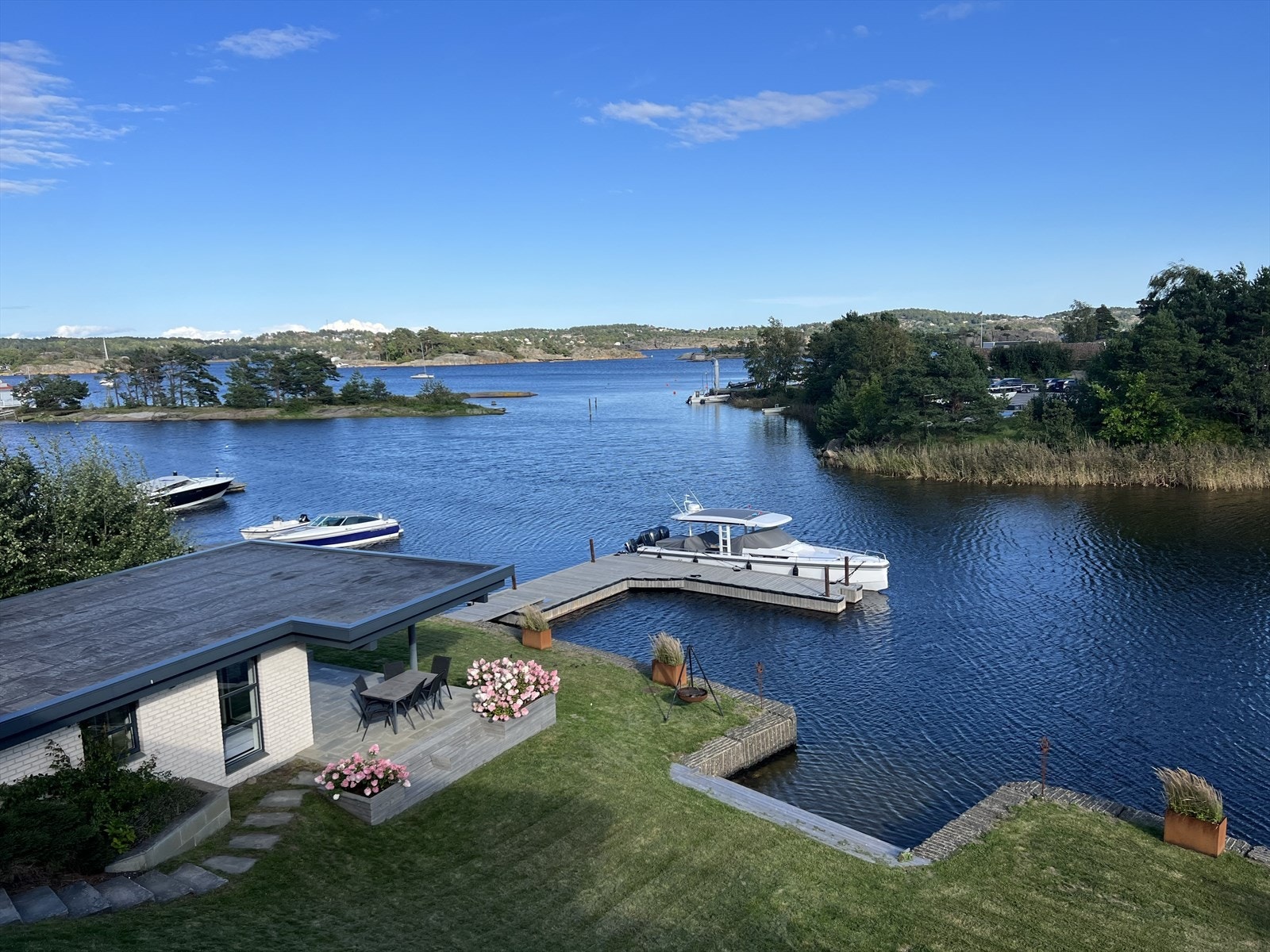 Nede ved vannet har eiendommen et strandhus med egen terrasse - oppført i samme stil som hovedboligen. Galleribilde