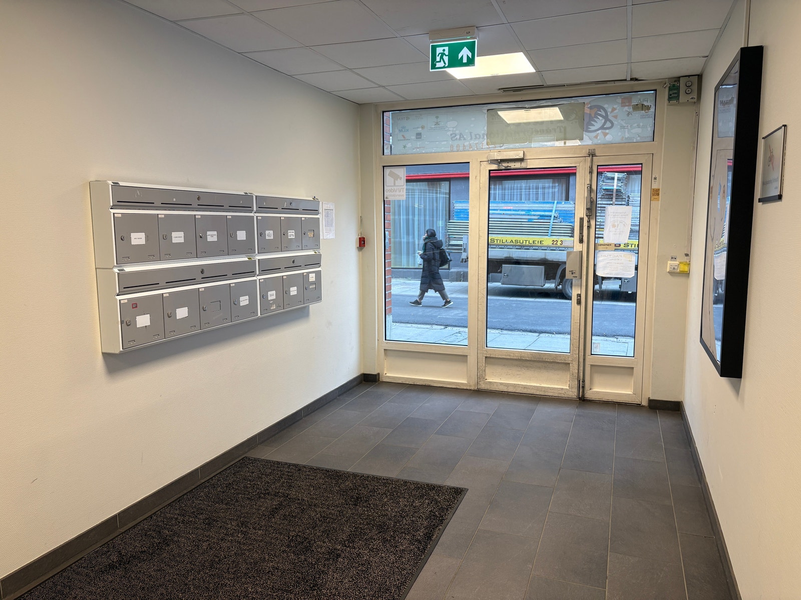 Inngangsparti med heis og infoskjerm for leietakeroversikt. Galleribilde