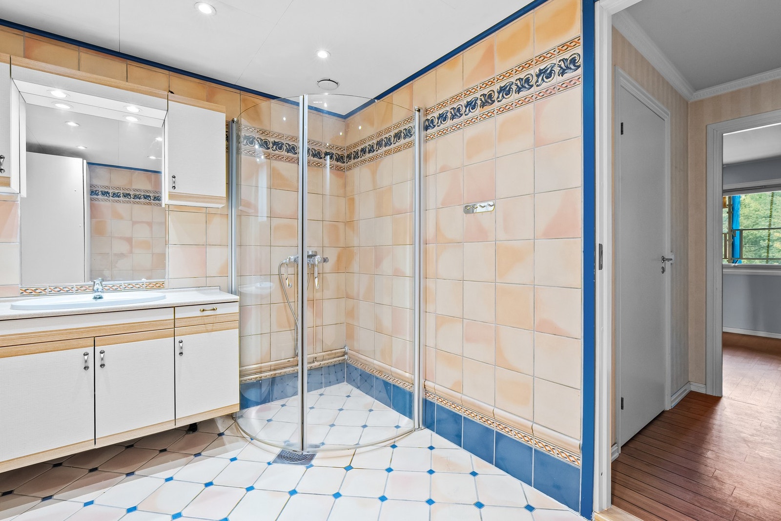 Badet har fliser på gulvet, fliser på veggene, gulvvarme, downlights og opplegg for vaskemaskin. Galleribilde