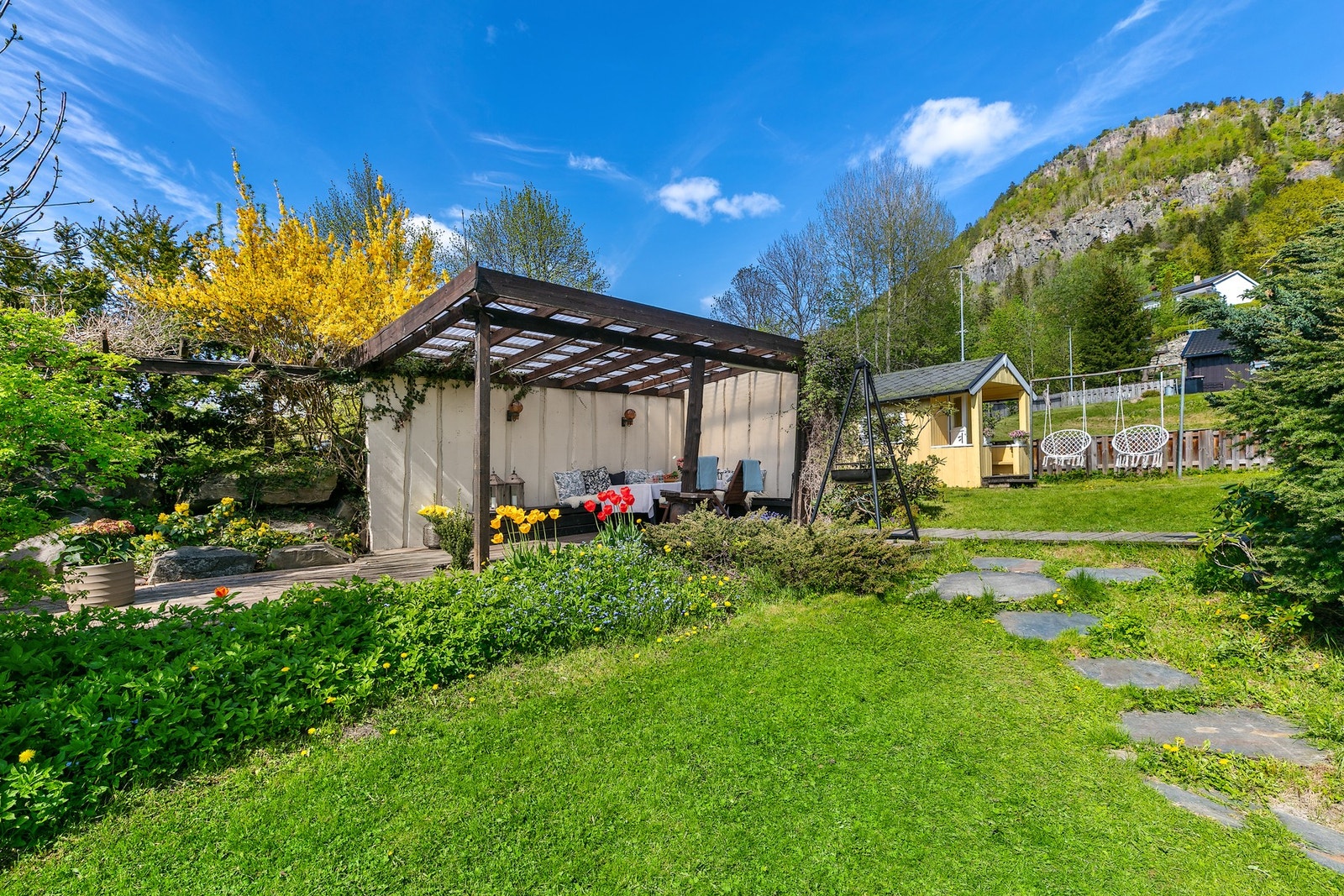 Hagen inkluderer en forseggjort hagestue/terrasseplatting med overbygg. Galleribilde