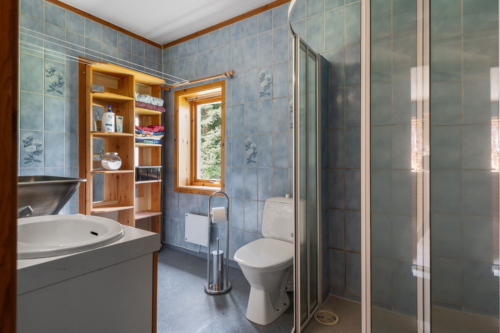 Baderommet er utstyrt med servantskap, dusjhjørne, gulvstående toalett, utslagskum og opplegg for vaskemaskin. Galleribilde