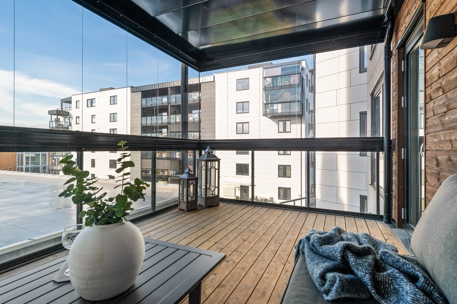 Balkongen har terrassebord på gulv og store glassfelt som kan åpnes opp. Siden balkongen er innglasset blir dette en fin forlengelse av stuen som kan brukes gjennom året. Galleribilde