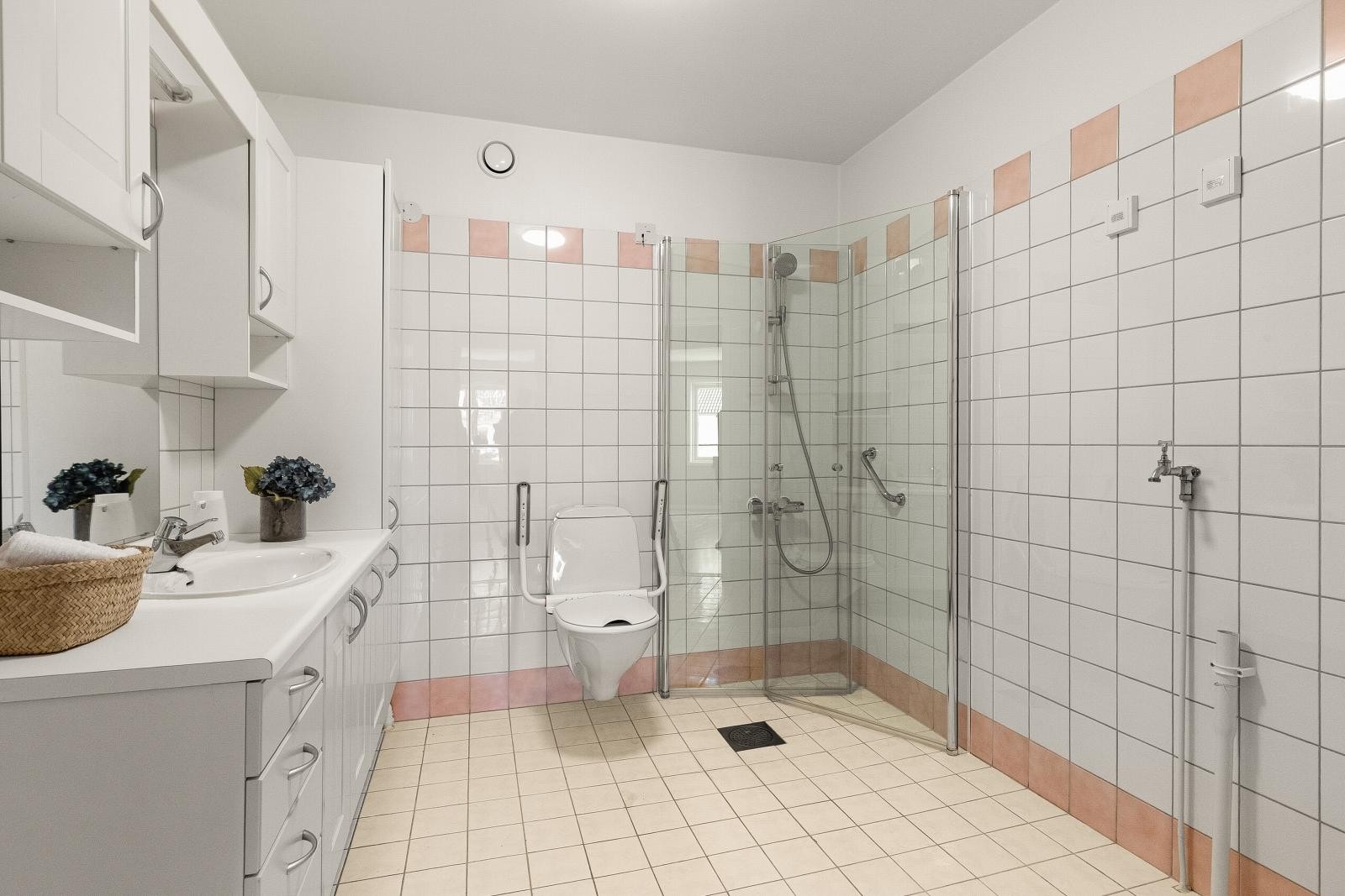 Flislagt bad med varmekabler, dusjvegg, vegghengt toalett og opplegg for vaskemaskin. Galleribilde