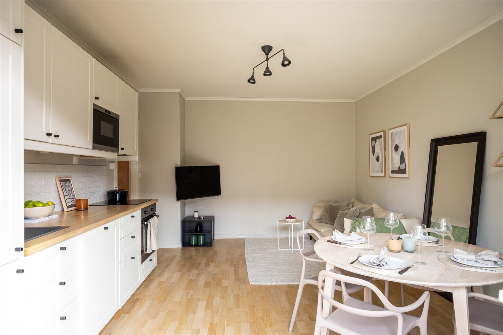 Lys og tiltalende stue, spiseplass og kjøkken i åpen løsning som skaper en sosial atmosfære. Galleribilde