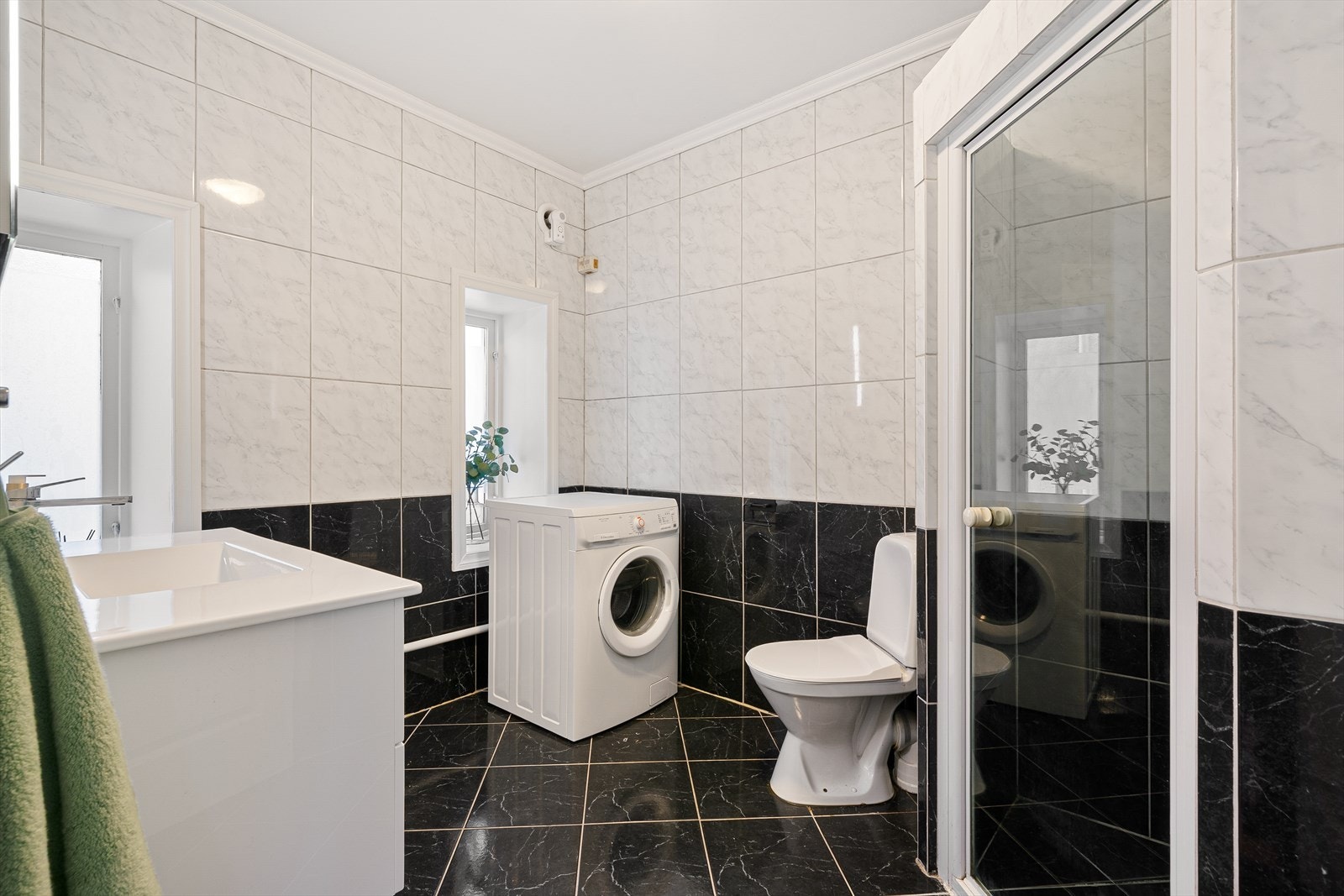 Badet på 6,5 m² har keramiske fliser på både gulv og vegger, som gir et elegant og tidløst uttrykk. Galleribilde