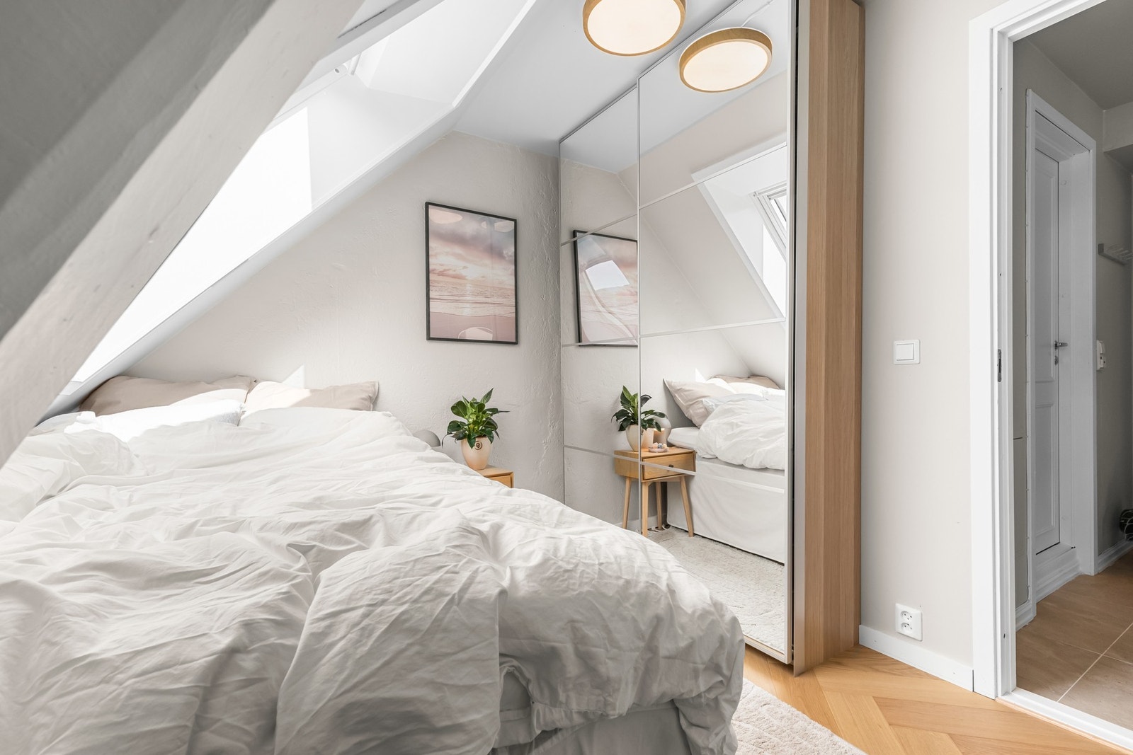 Langs den innerste veggen er det montert en takhøy skyvedørsgarderobe med speilfronte Galleribilde