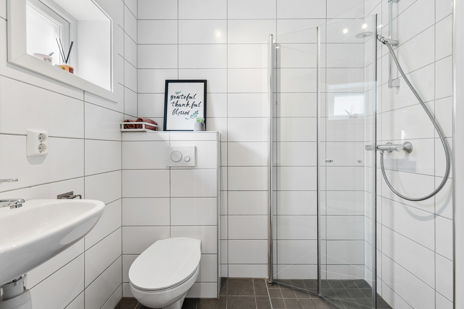 Dusjhjørne med dører og vegghengt toalett Galleribilde