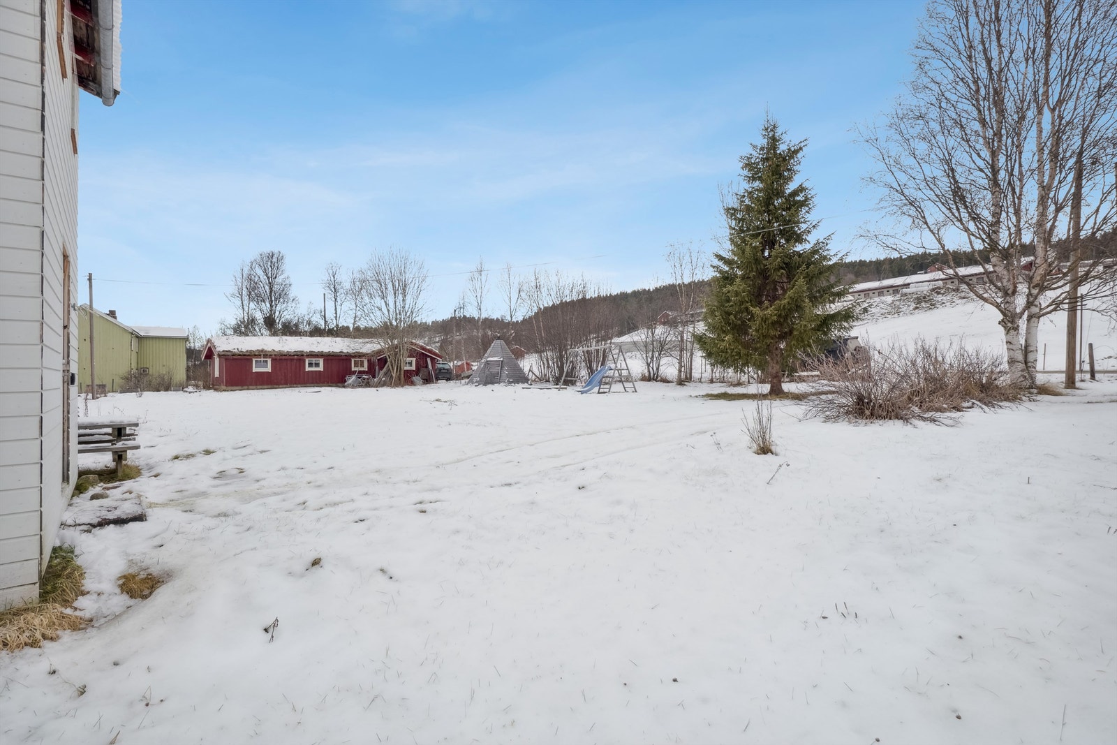 Romslig flat tomt på fremsiden av eiendommen som er opparbeidet med plen. Galleribilde