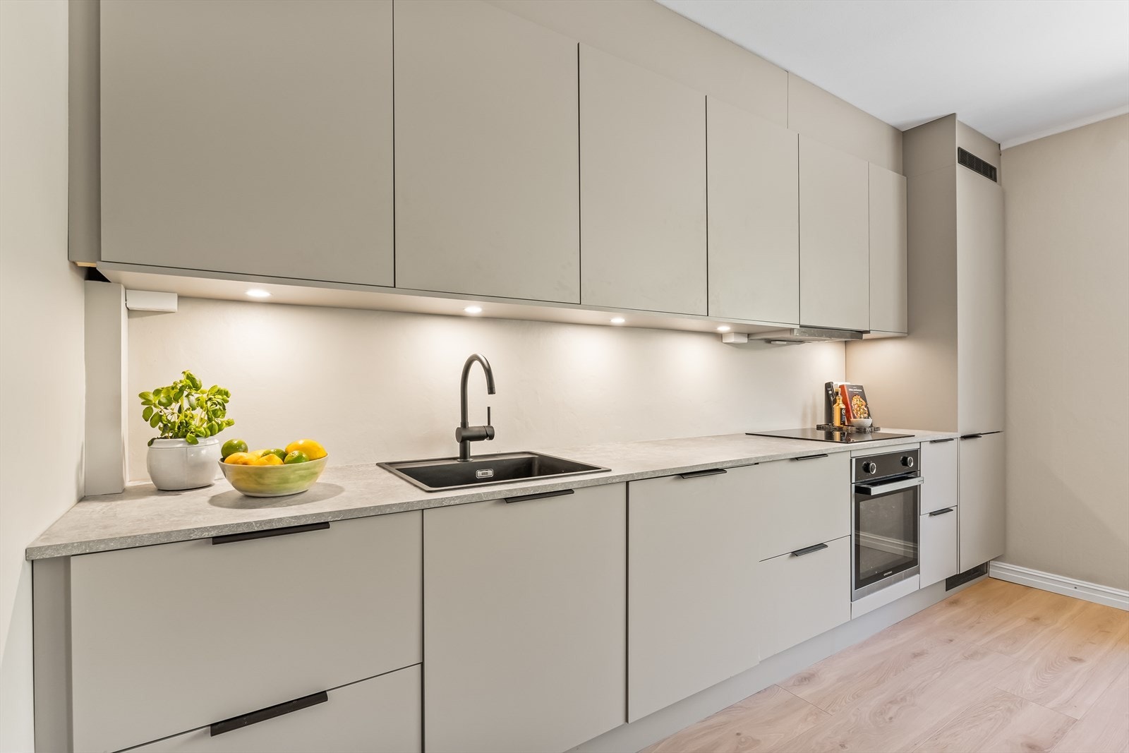 Kjøkkeninnredningen har glatte fronter med stekeovn, platetopp, kjøl/frys og oppvaskmaskin alt integrert i innredningen. Galleribilde