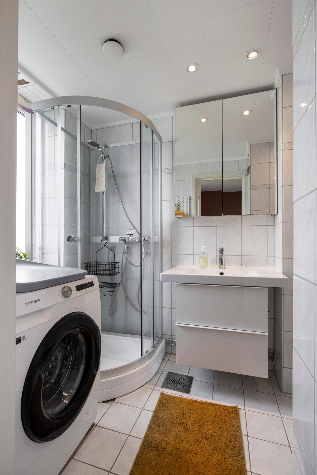 Badet har flislagte vegger og gulv med himlingsplater i taket, som er utstyrt med downlights Galleribilde