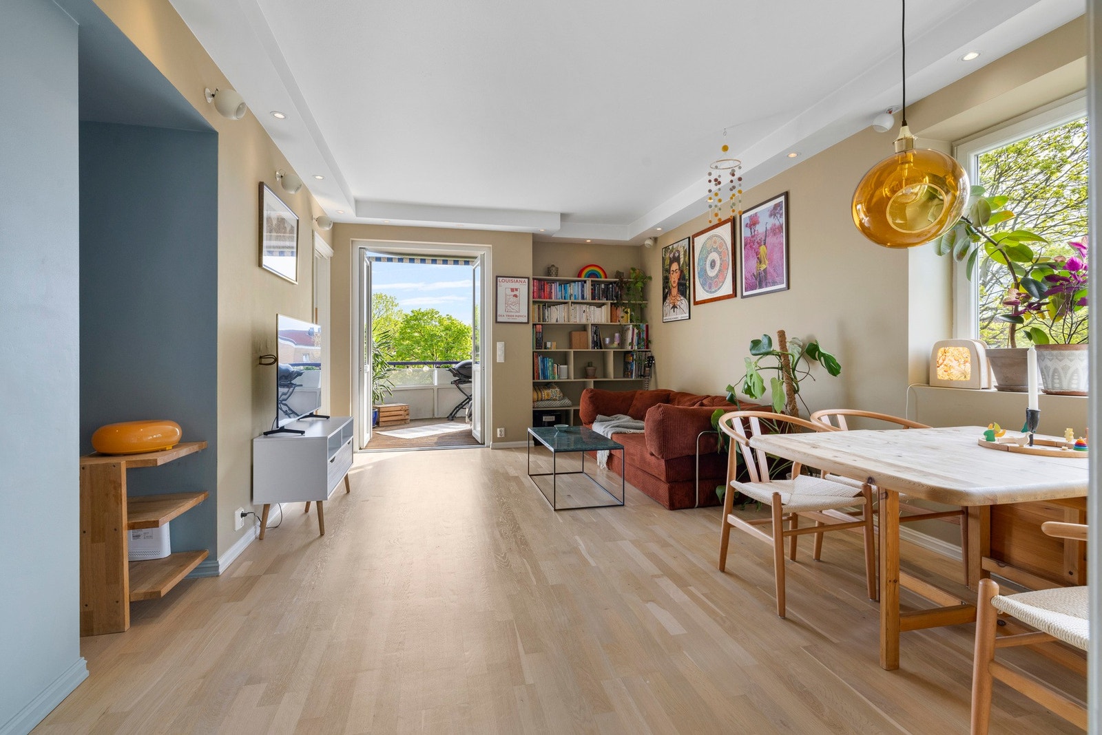 Lys og åpen stue med store vinduer og utgang til balkong Galleribilde