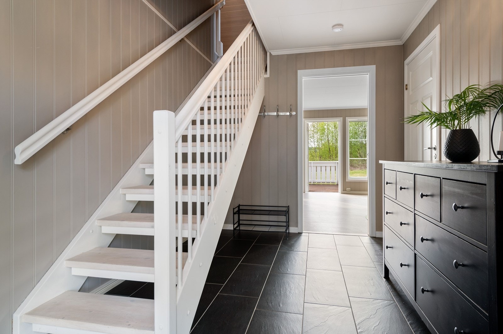 Hall mot stue, adkomst til soverom og bad fra entreen samt trappegang til 2.etasje. Galleribilde