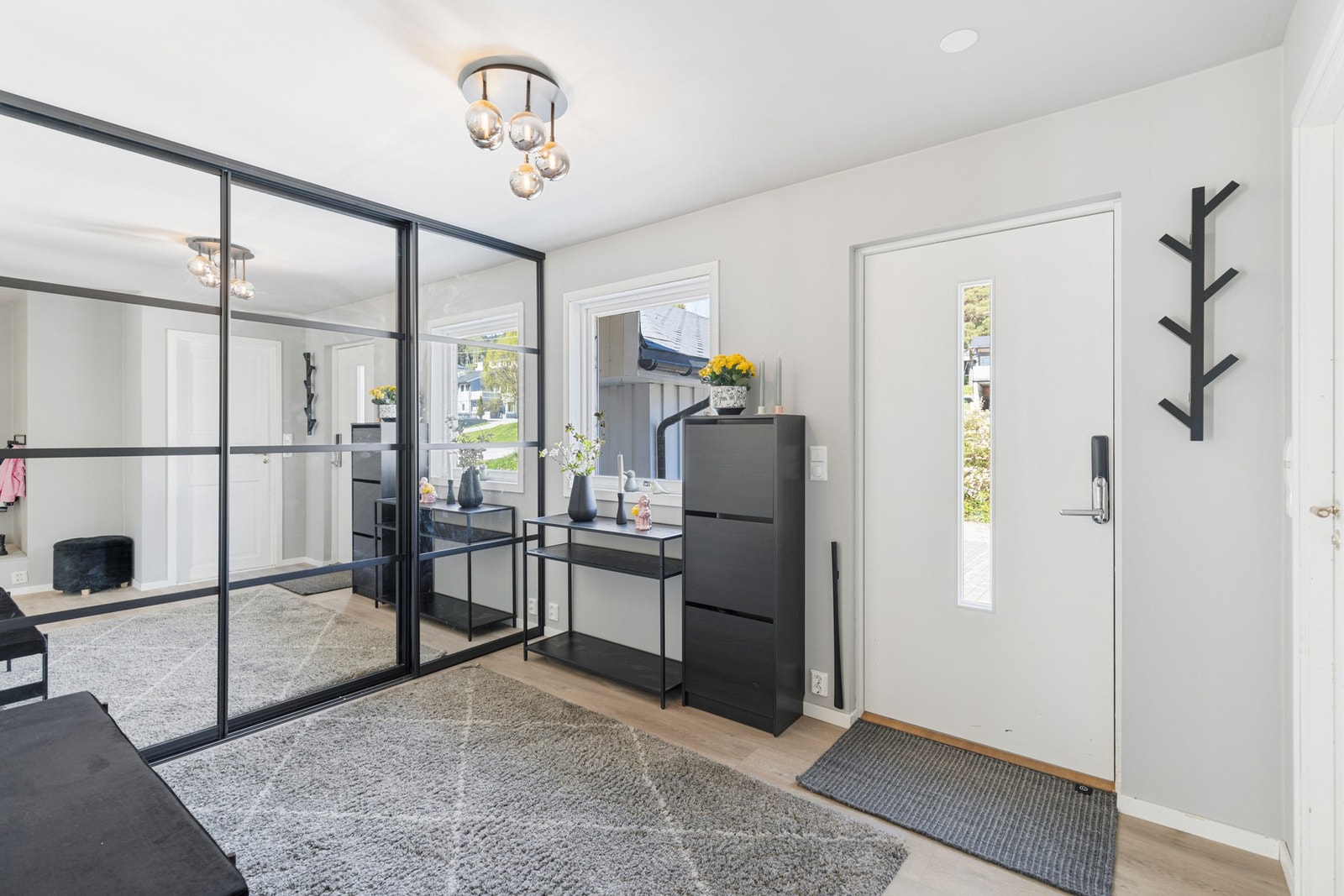 Romslig hall med flislagt gulv og stor skyvedørsgarderobe. Galleribilde