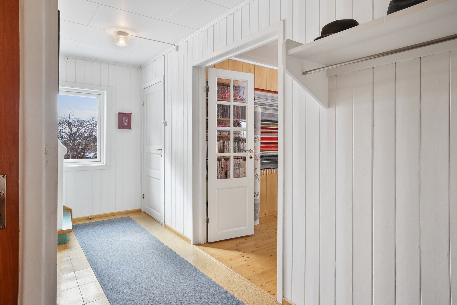 Fra entré kommer man videre til gangen med garderobeløsning. Her er trapp opp til loft, kjeller og øvrige rom i boligen. Galleribilde