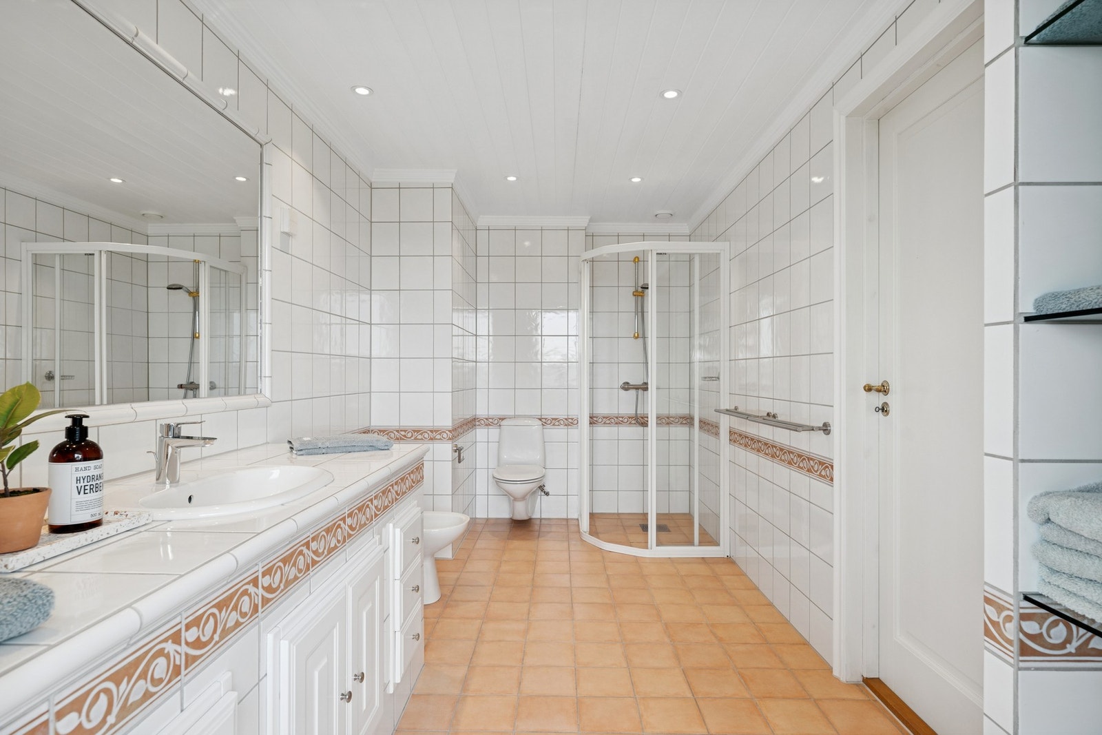 Romslig bad med dusjkabinett, vegghengt toalett og bidé. Et lyst og funksjonelt bad med gjennomgående klassisk preg. Galleribilde