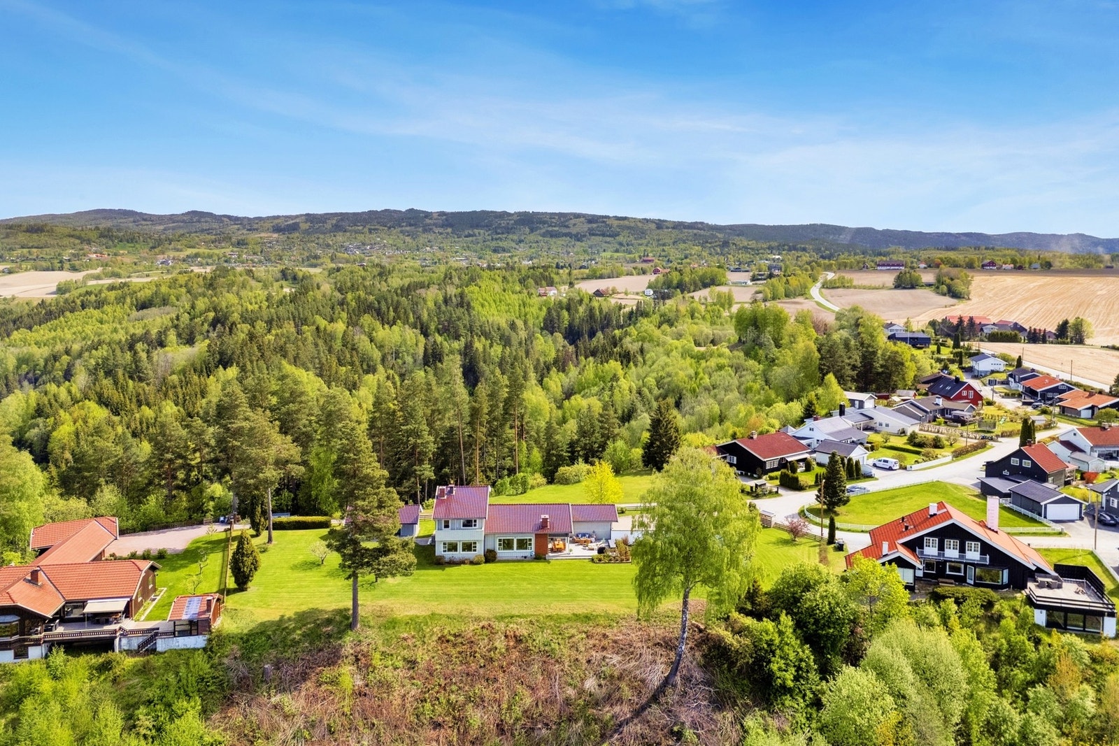 Eiendommen ligger høyt og fritt med vidstrakt utsyn over byen og omkringliggende åser. Her bor du tilbaketrukket og skjermet - med gangavstand til sentrum og kort vei til alt du trenger i hverdagen. Galleribilde