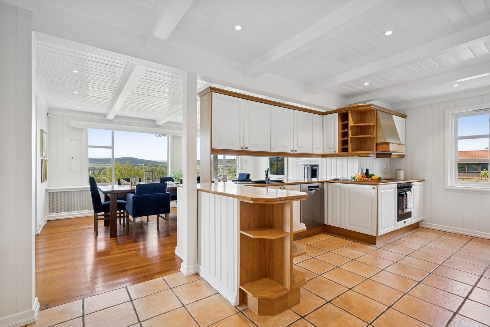 Kjøkkenet ligget i moderne åpen løsning mot spisestuen - innredningen kombinerer tidløst uttrykk med praktiske løsninger Galleribilde